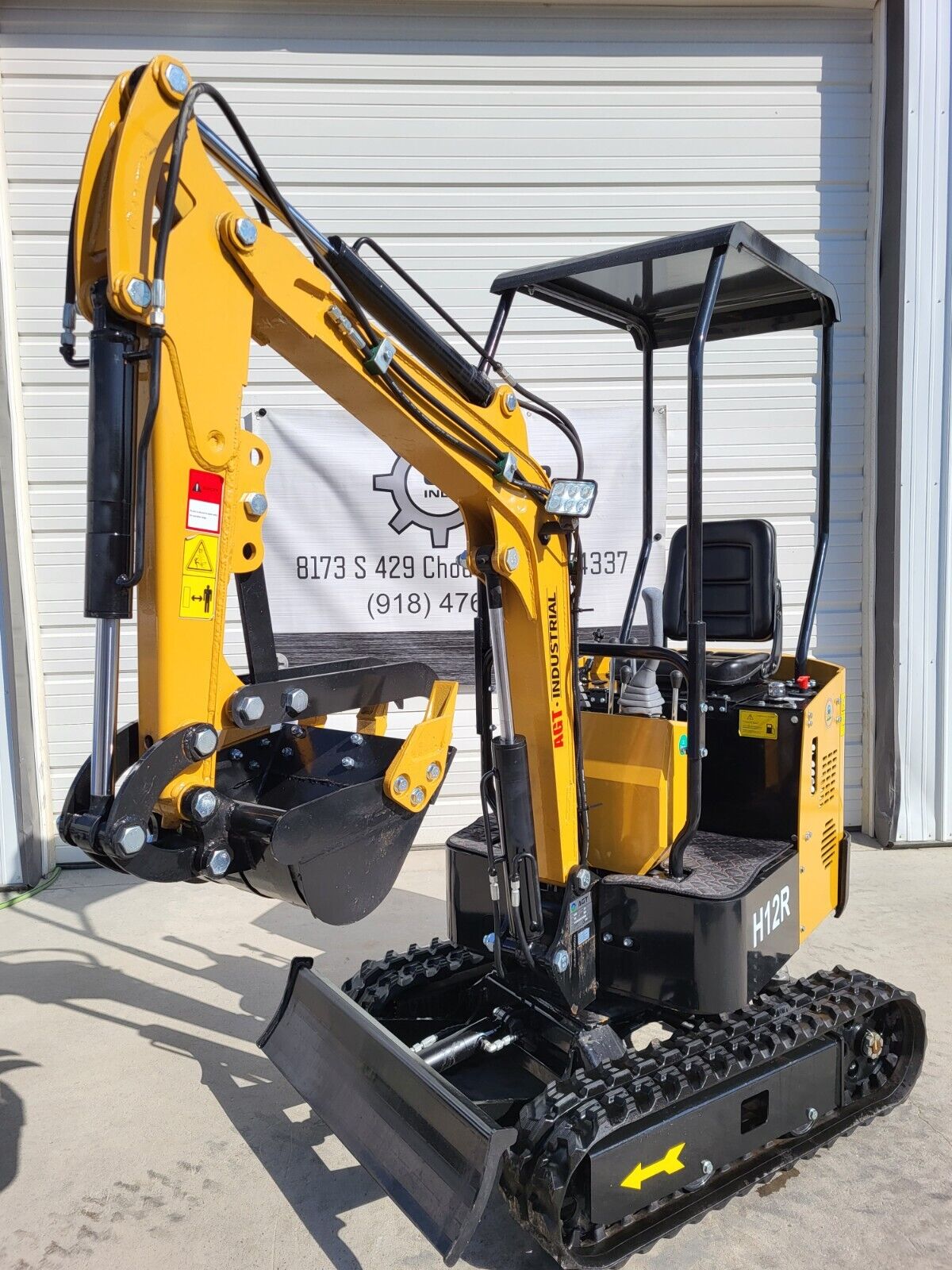 AGT H12R mini excavator with the boom folded and the bucket curled under the fixed thumb, canopy and seat