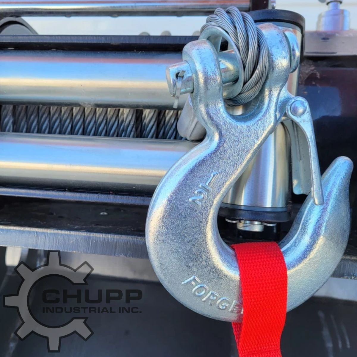 Arteer logging winch: forged slip hook with safety latch and red pull strap on the steel cable, drum behind
