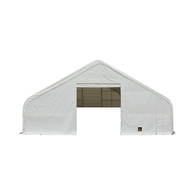 Dual truss fabric building, white PVC cover, open drive-through door in the end wall with a man door alongside