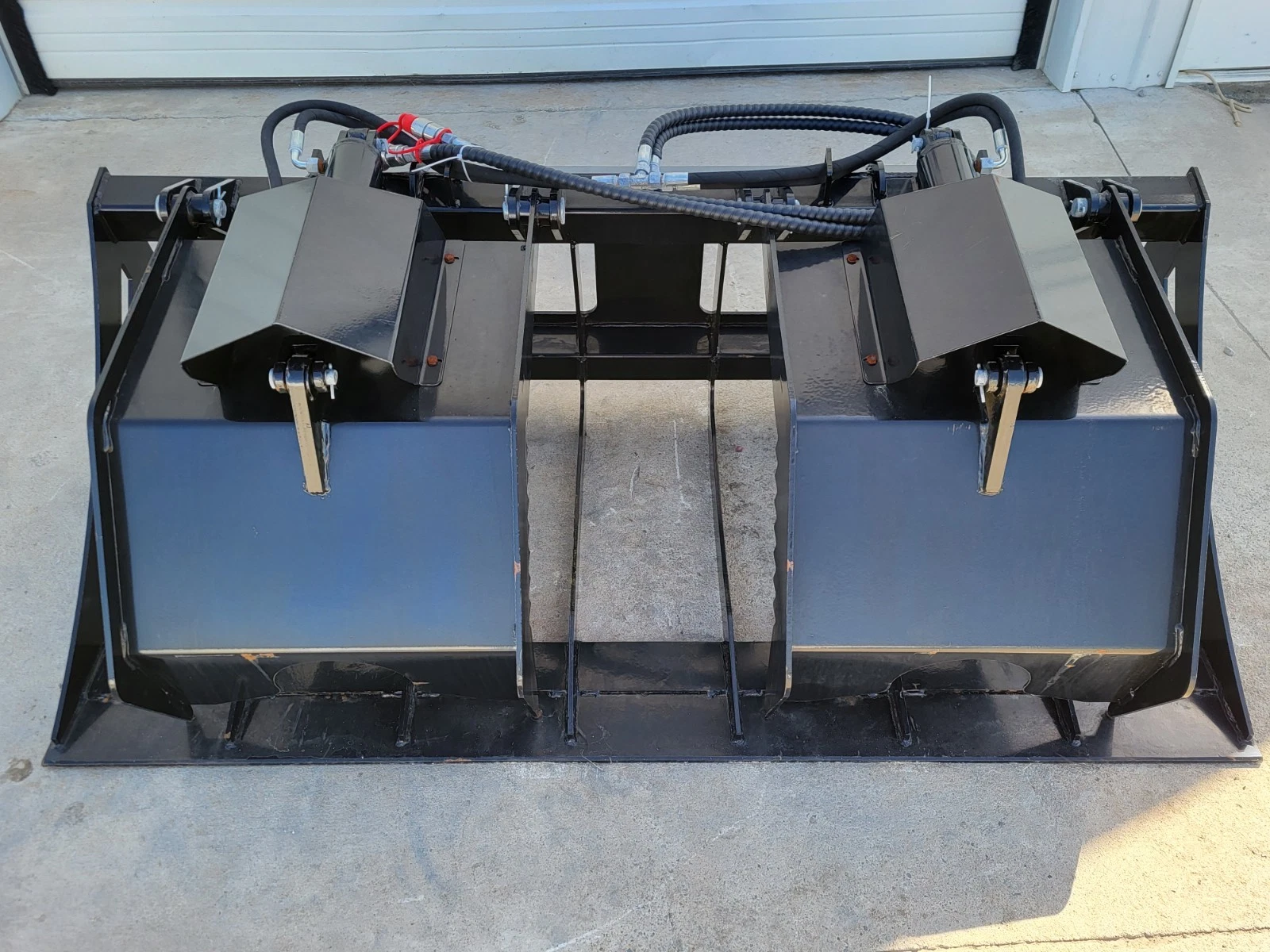 72-inch root grapple bucket, dual top clamps closed, spaced tines and full-width cutting edge