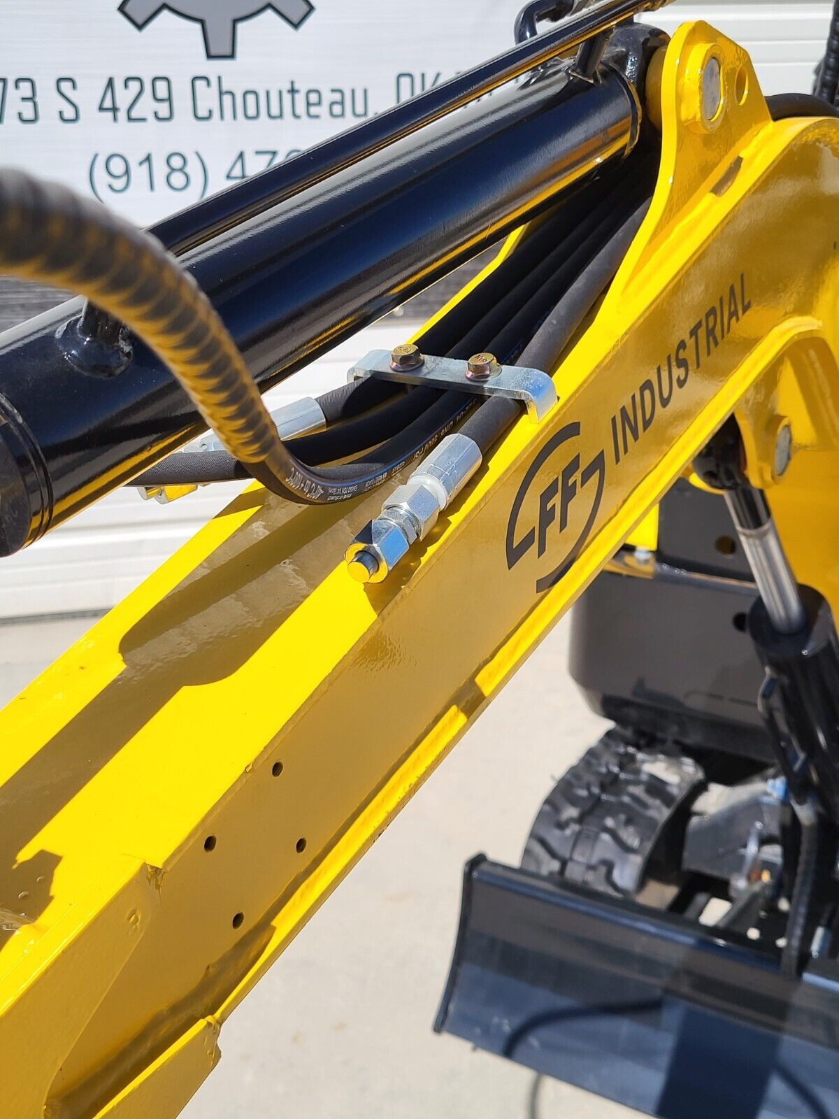 FF15 boom close-up: FF Industrial decal, boom cylinder and the auxiliary hydraulic lines with their coupler fitting