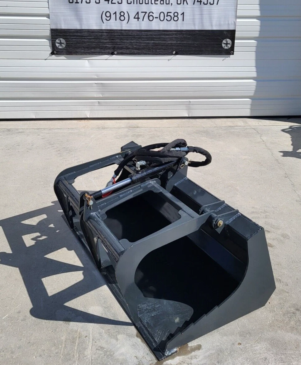 Gray flat-bottom grapple bucket with closed grapple arm, hydraulic cylinder and sleeved hoses