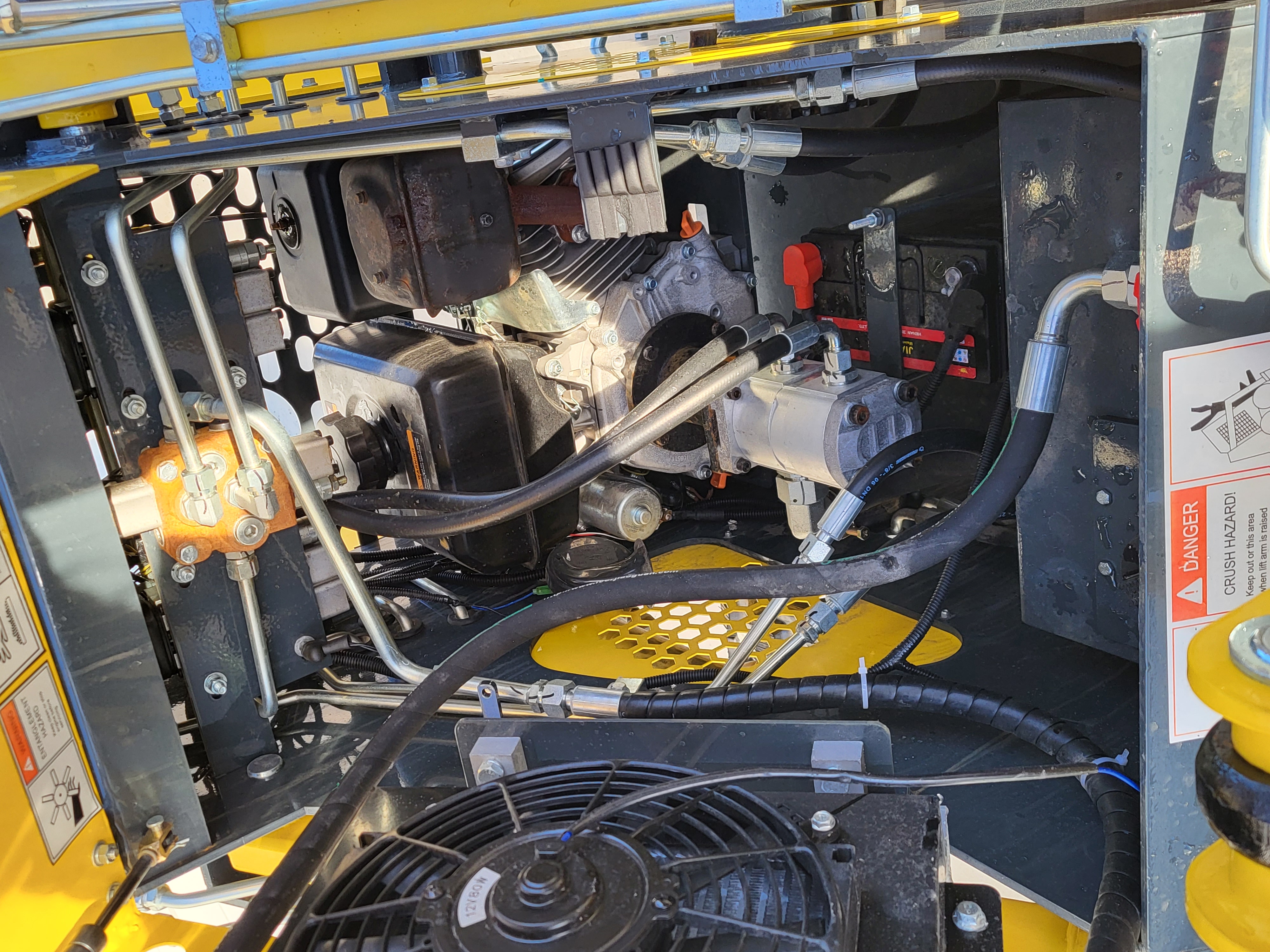 EG360 engine bay: gasoline engine with muffler, hydraulic gear pump, electric cooling fan and battery