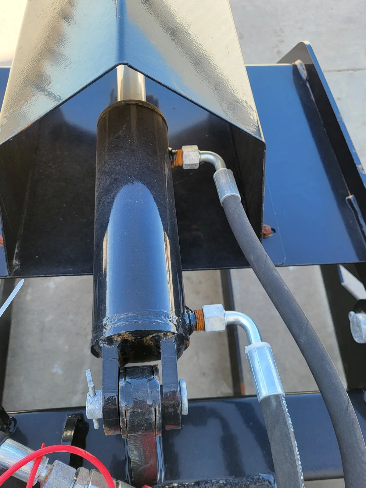 Root grapple clamp cylinder under the clamp shell, elbow fittings and hydraulic hoses on both ports