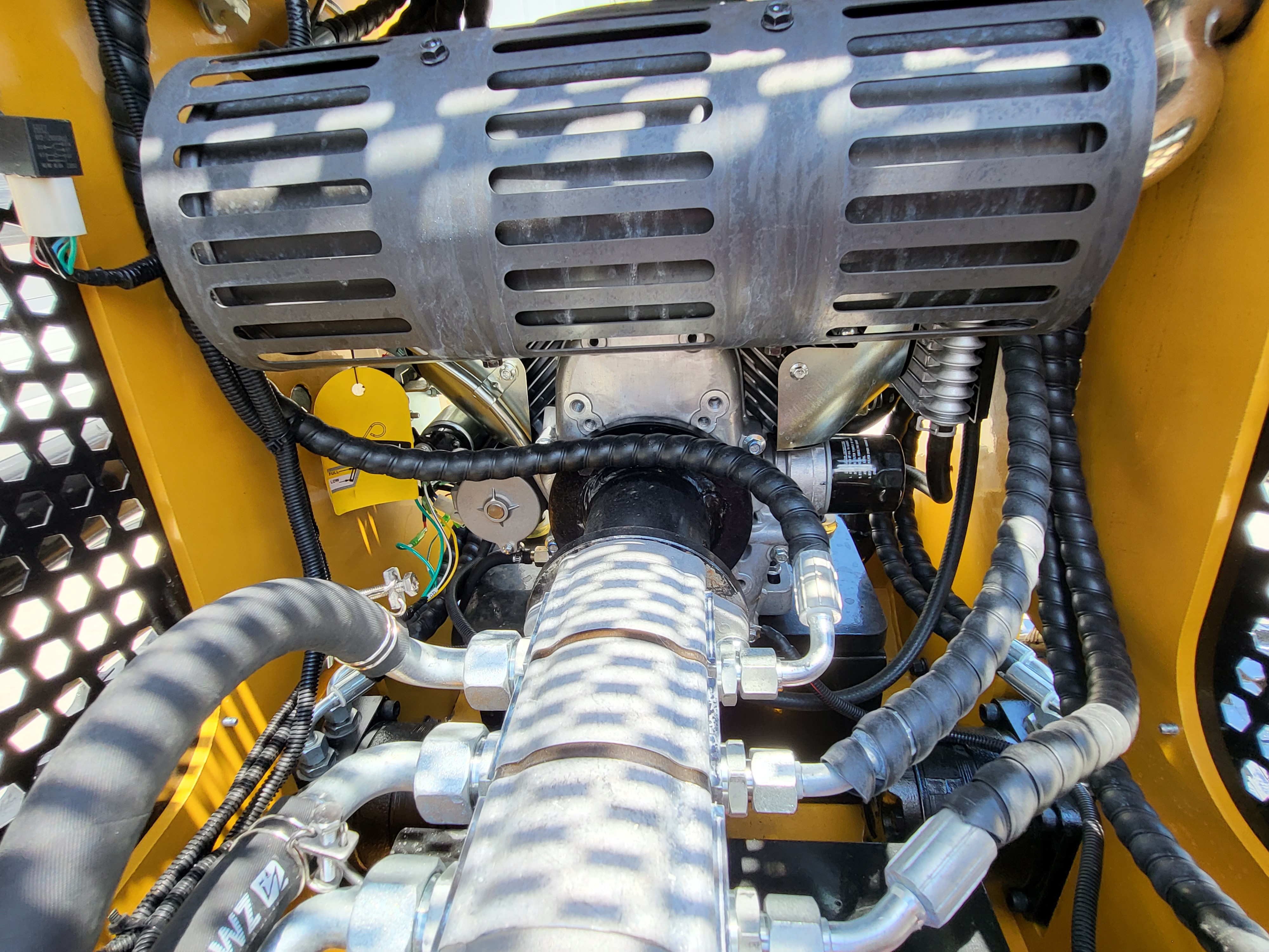 AGT CRT23 engine bay: shielded muffler above the engine, spin-on oil filter and braided hydraulic lines