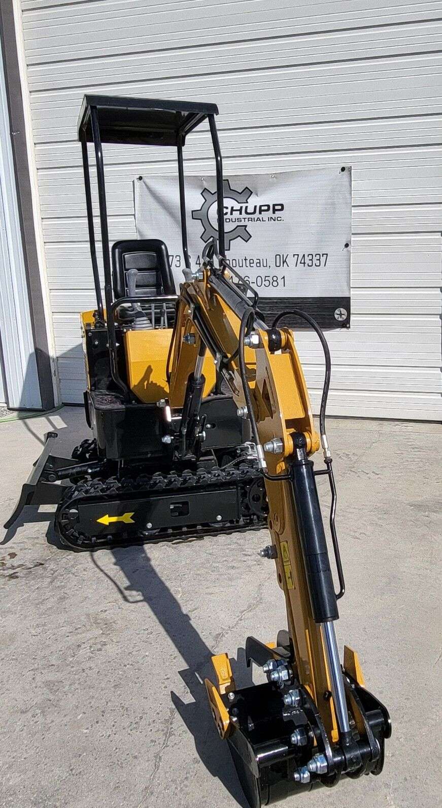 AGT H12R mini excavator with the boom swung out over the tracks and the stick and thumb lowered to the ground