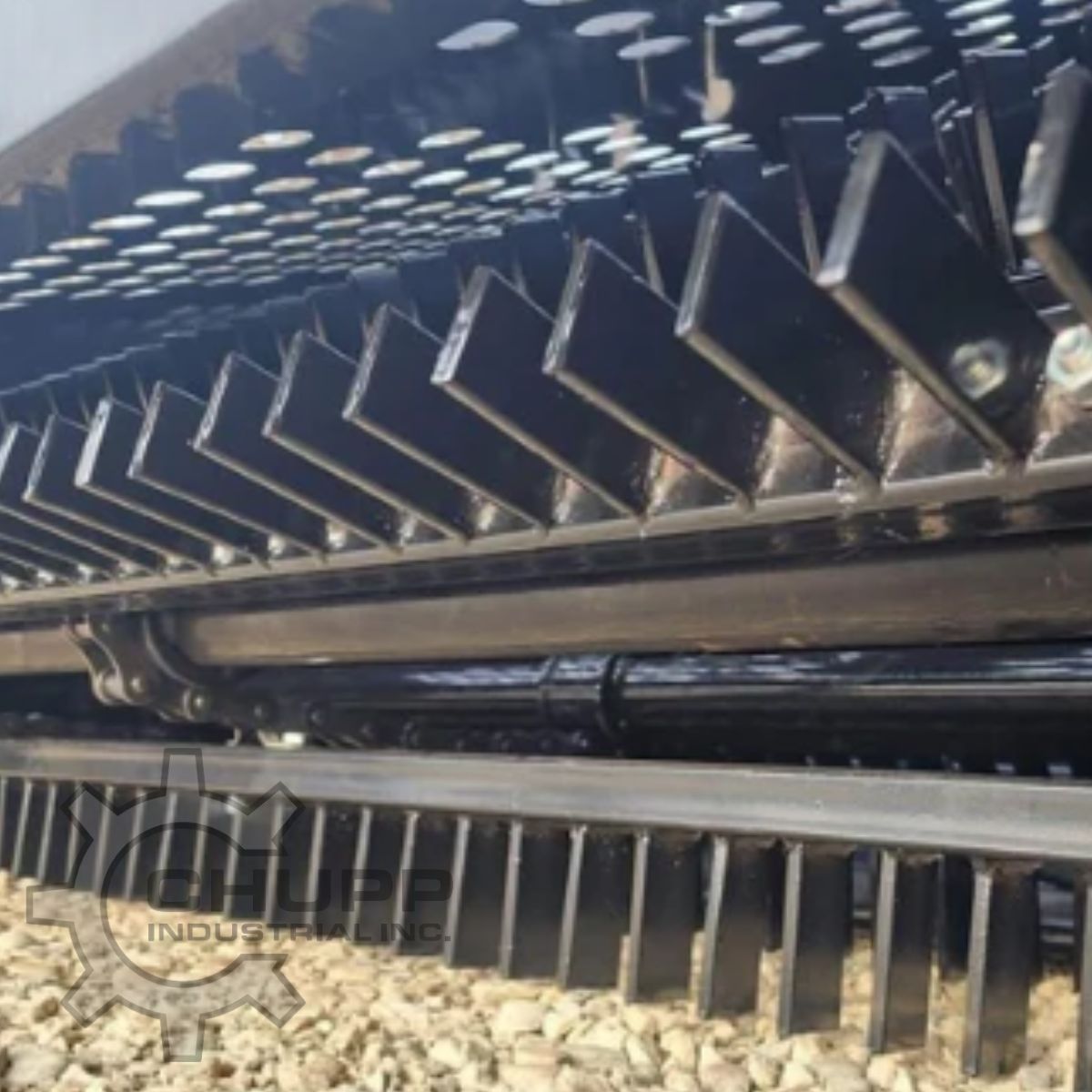 AGT landscape rake teeth up close: angled steel paddles on the pickup drum above the full-width comb