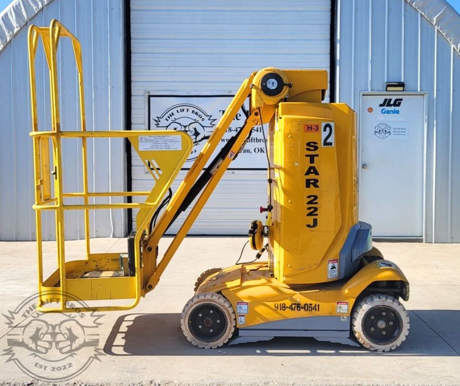STAR 22J vertical mast lift in yellow, jib boom folded down, platform lowered, four solid tires