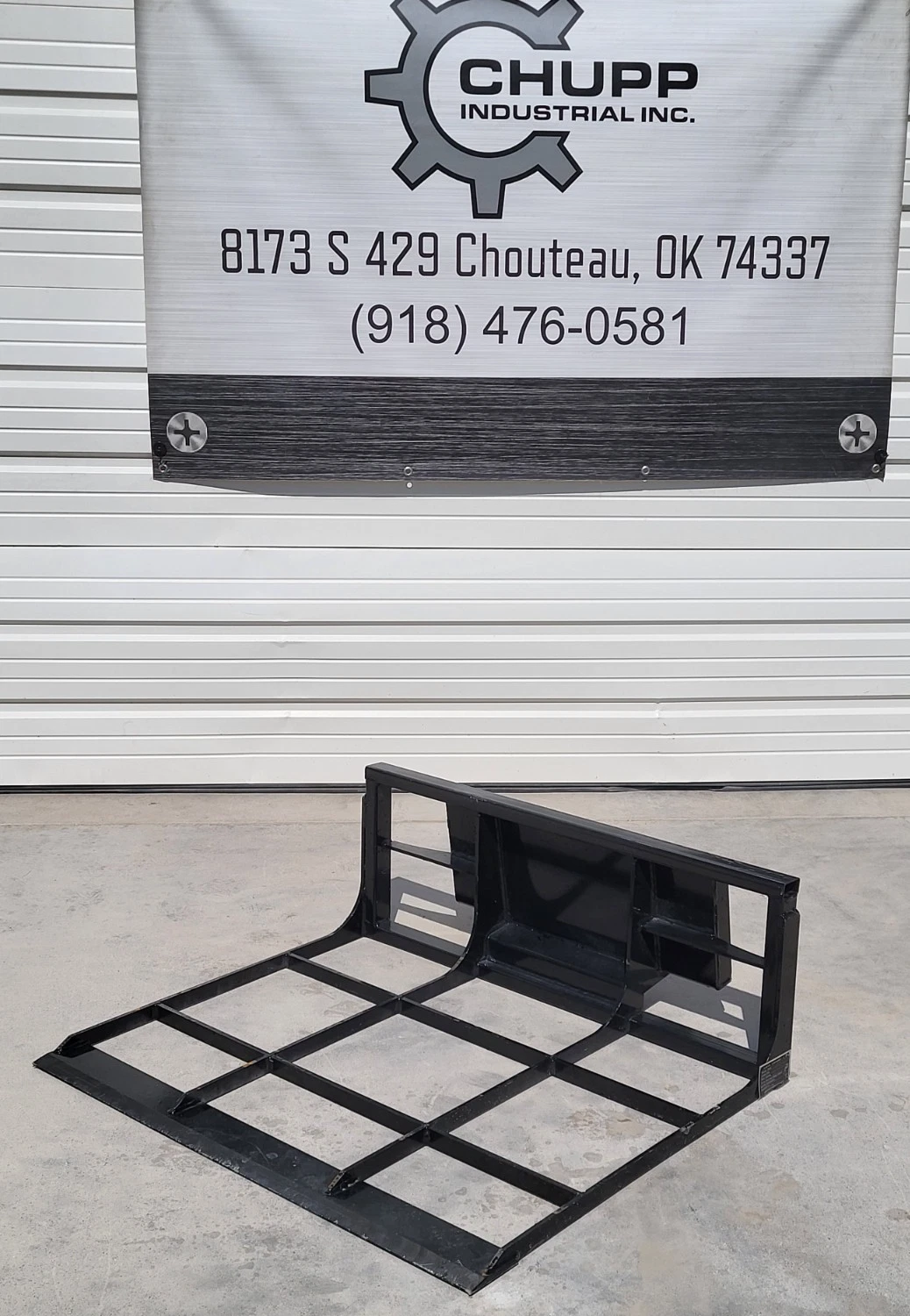 Black steel land leveler with open grid frame and flat cutting edge, below the Chupp Industrial banner
