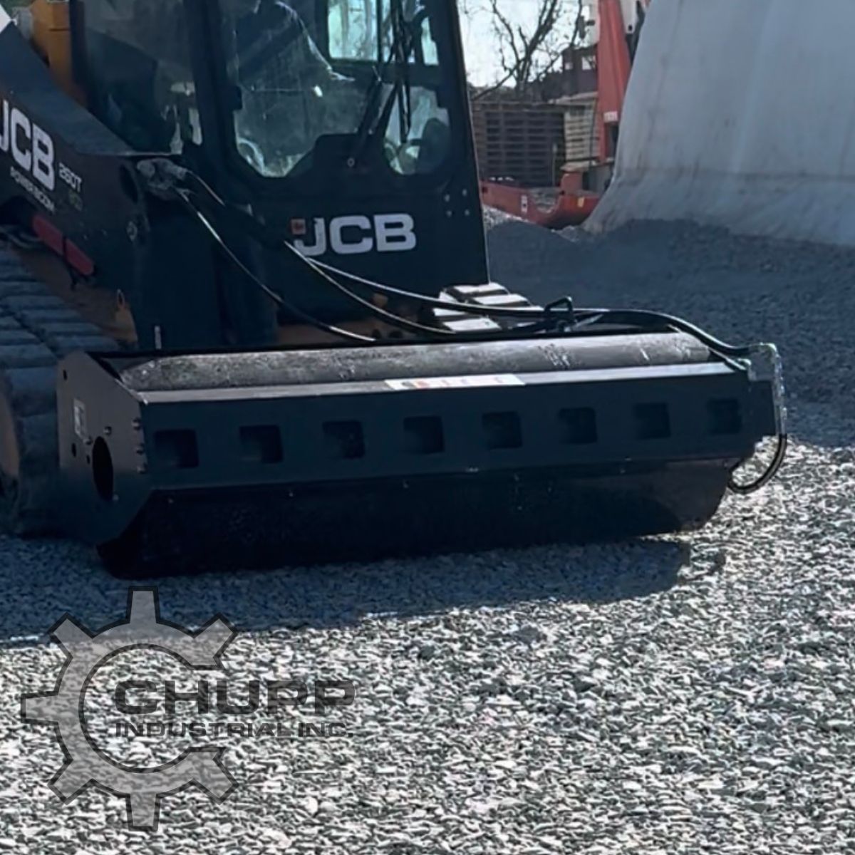 Wolverine vibratory roller mounted on a JCB track loader, drum compacting a gravel pad