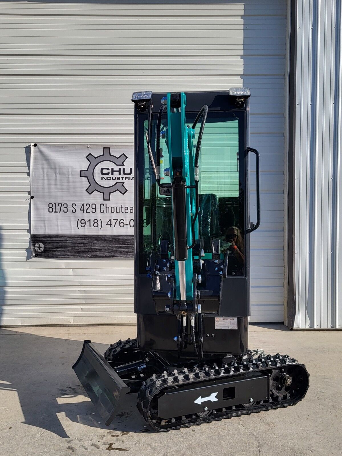 FF13 mini excavator head-on: boom cylinder folded in front of the cab, work lights, dozer blade and rubber tracks