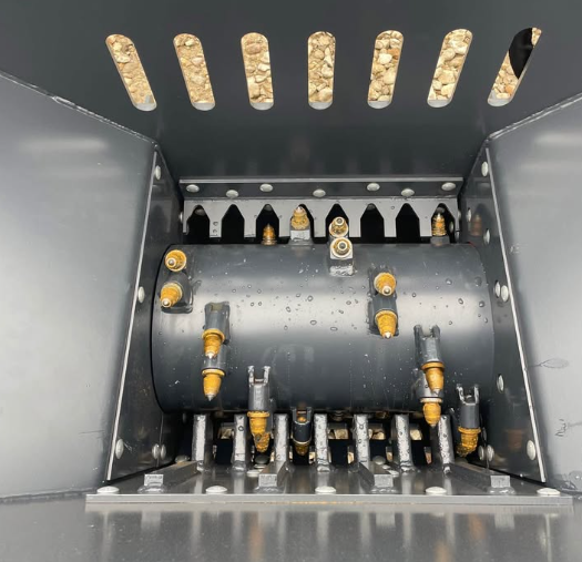 Inside the WIG block crusher hopper: carbide-tooth crushing rotor and breaker teeth above the discharge slots