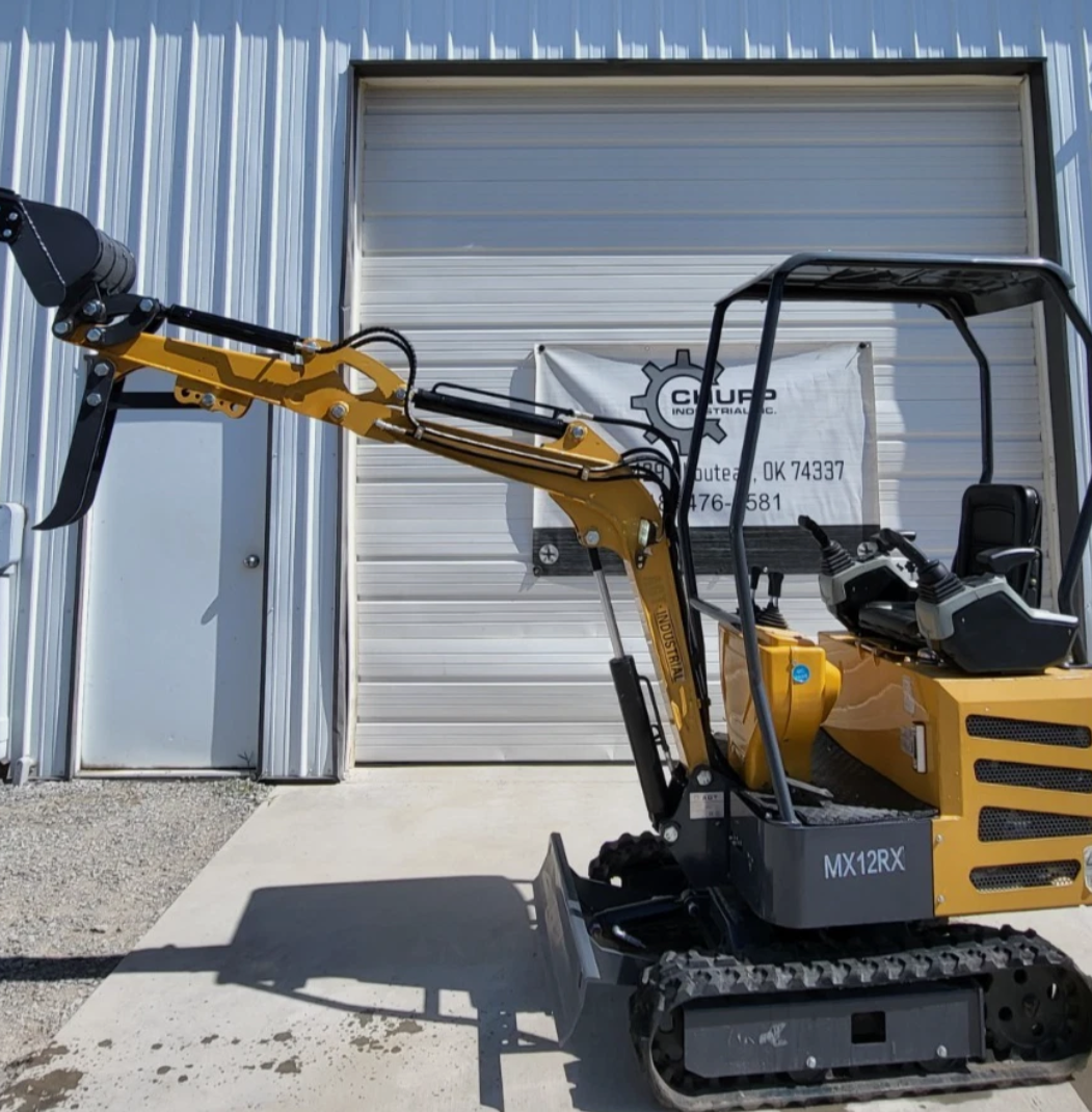 MX12RX 1-ton mini excavator with the boom reached out, toothed bucket raised and the mechanical thumb open