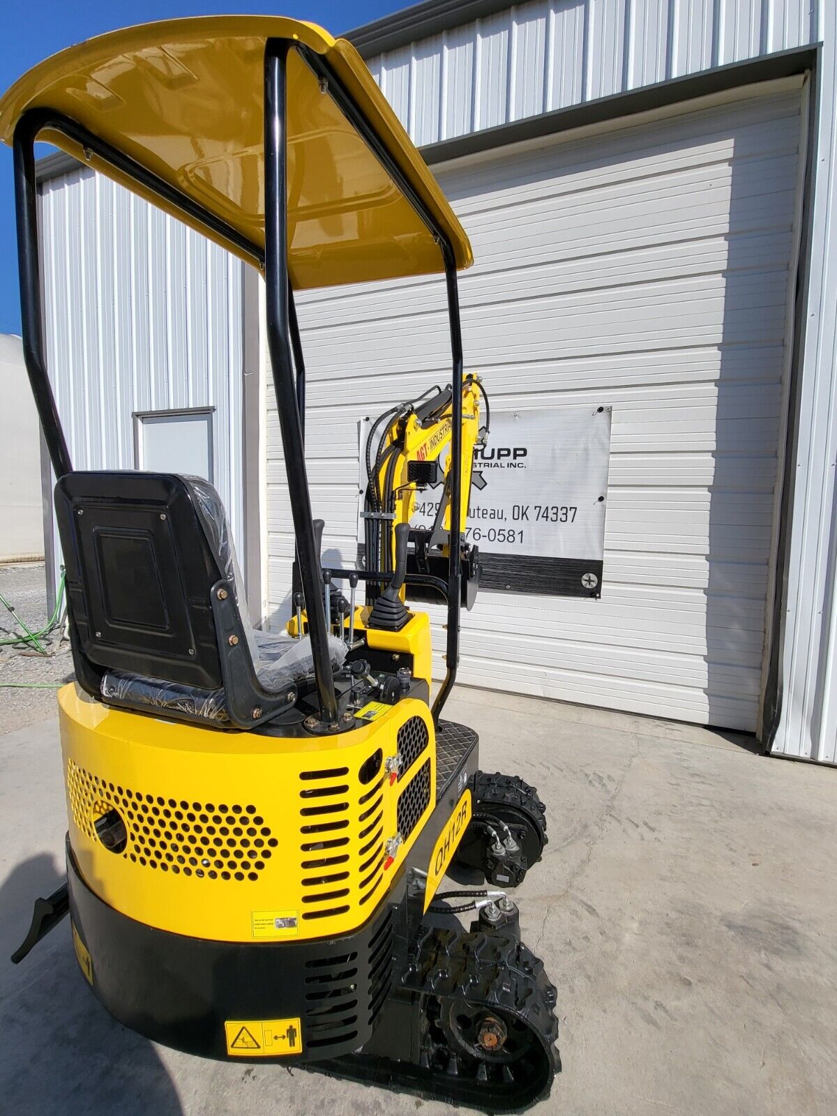 Yellow AGT QH12R mini excavator: canopy, seat, joystick controls and vented engine cover over the tracks