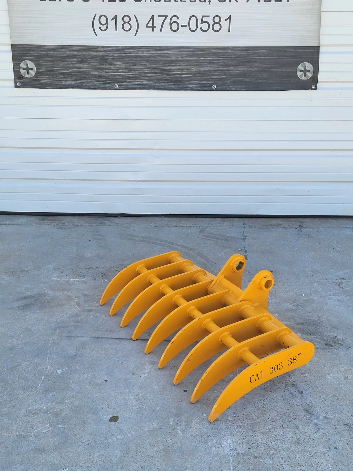 Yellow 38-inch excavator root rake, eight curved tines and twin pin-boss mounting ears