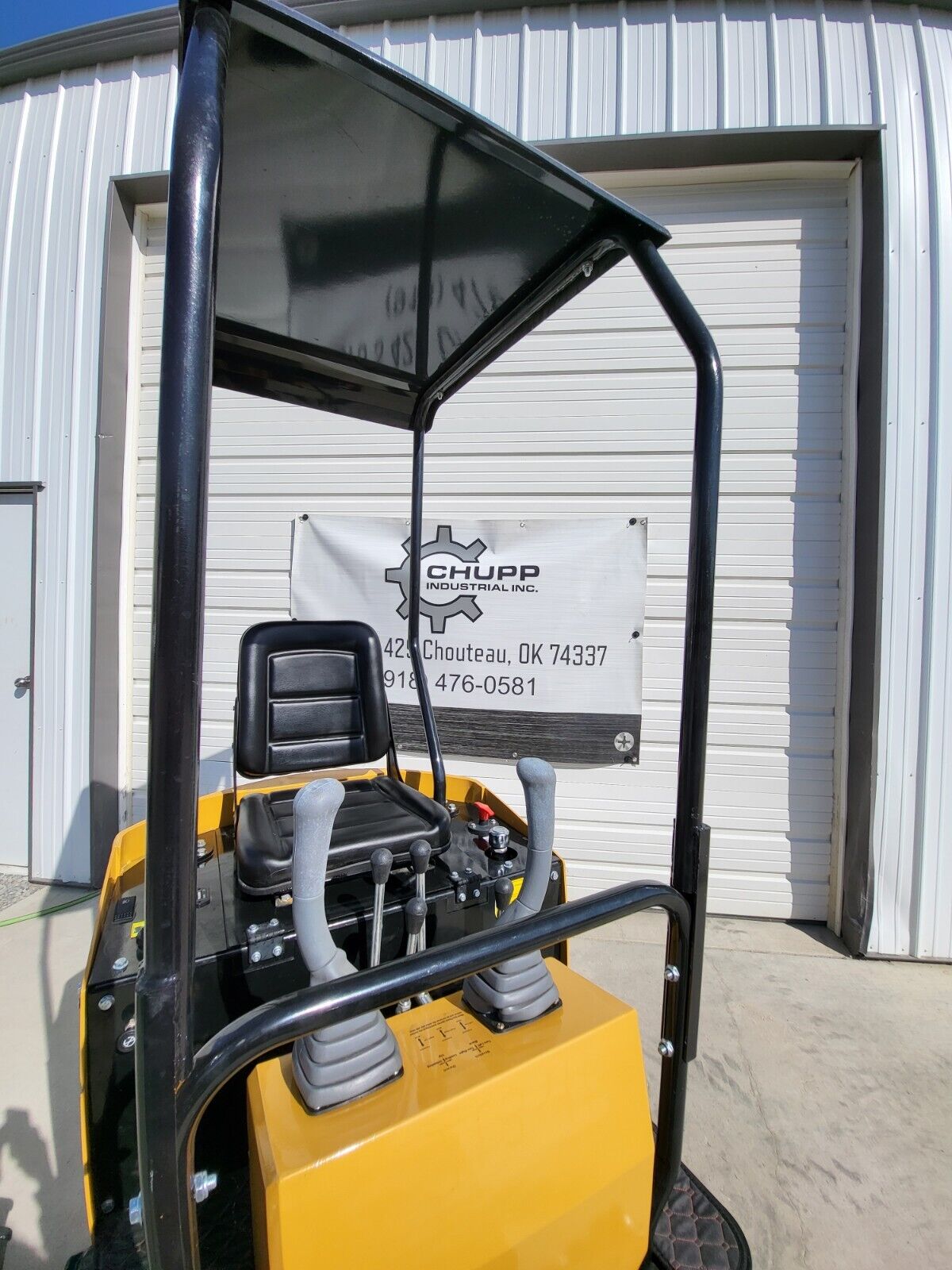 AGT H12R mini excavator seat under the black canopy, with joysticks, track levers and red kill switch