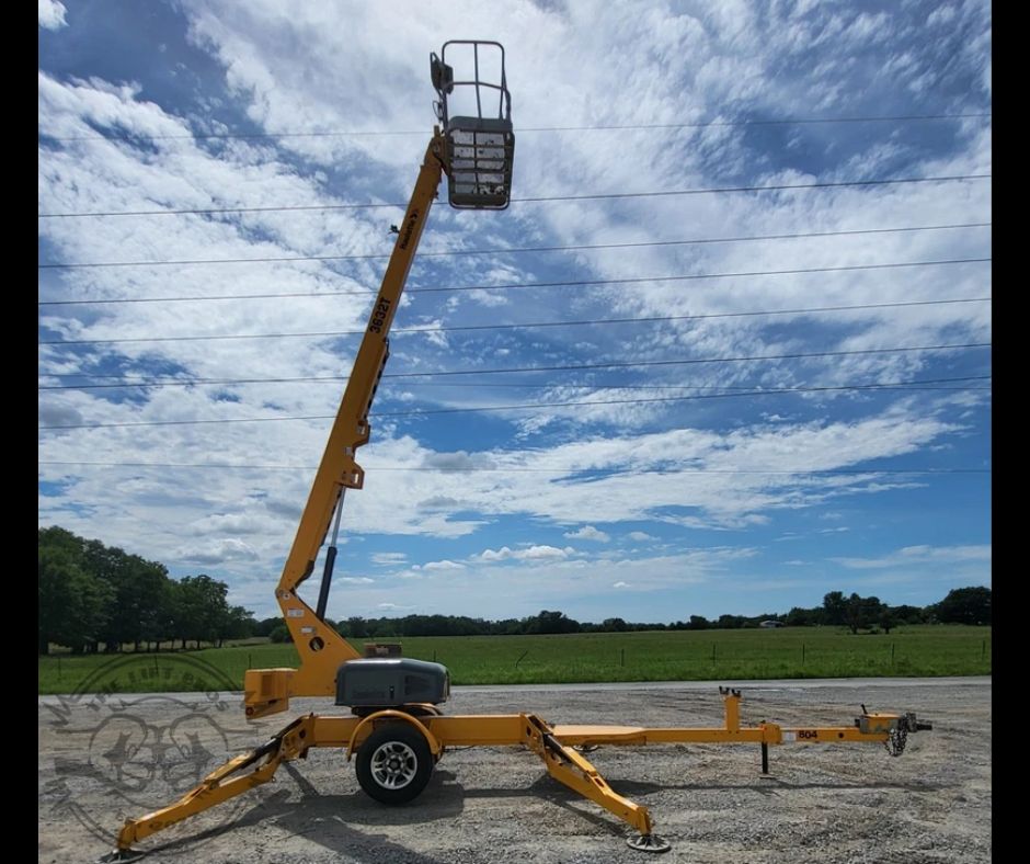 Yellow Haulotte 3632T towable boom lift with the boom raised near vertical on deployed outriggers