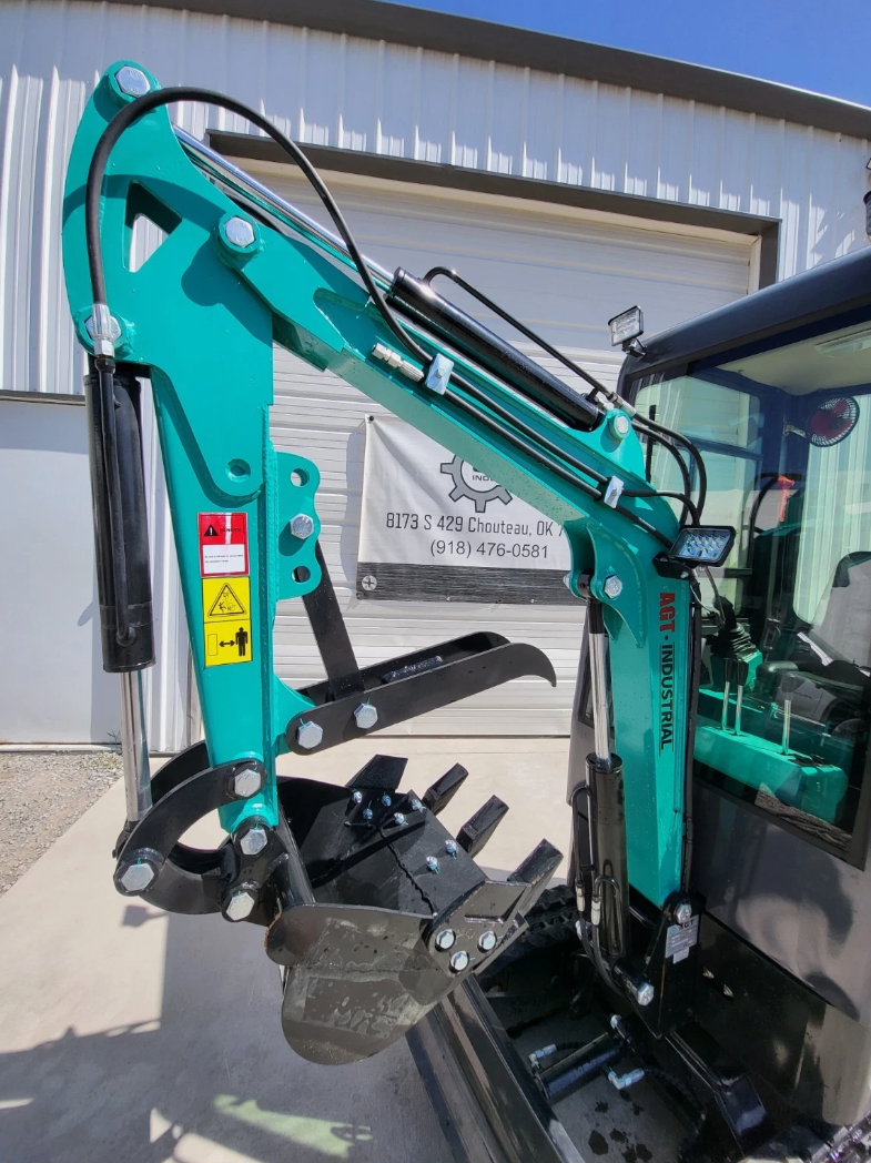 MH13RX mini excavator boom: teal arm with hydraulic cylinders, work light and toothed bucket with hydraulic thumb