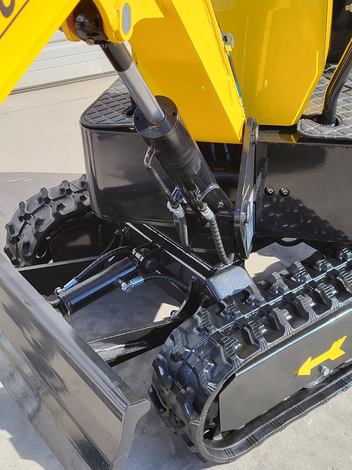 AGT QH12R boom swing cylinder and hydraulic lines above the backfill blade and rubber tracks