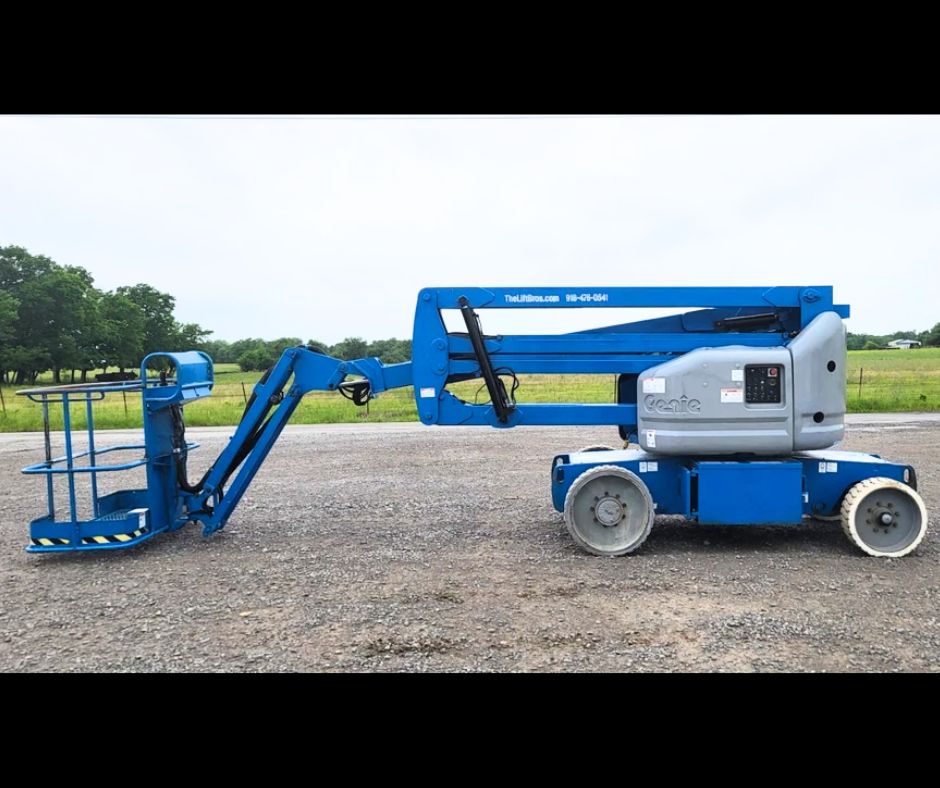 Blue Genie articulating boom lift, boom folded down over the chassis, work platform lowered, solid rubber tires