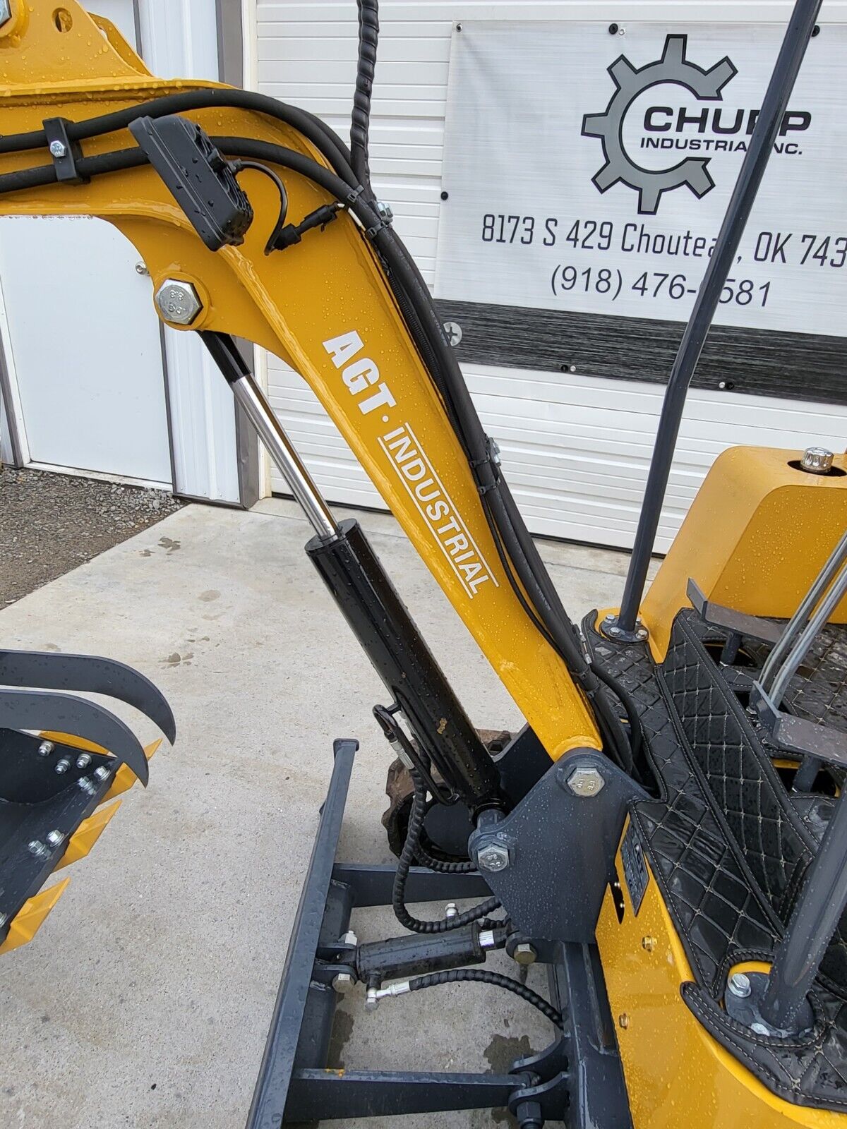 AGT H15 yellow boom with the AGT Industrial decal, boom cylinder and hydraulic hoses running to the bucket