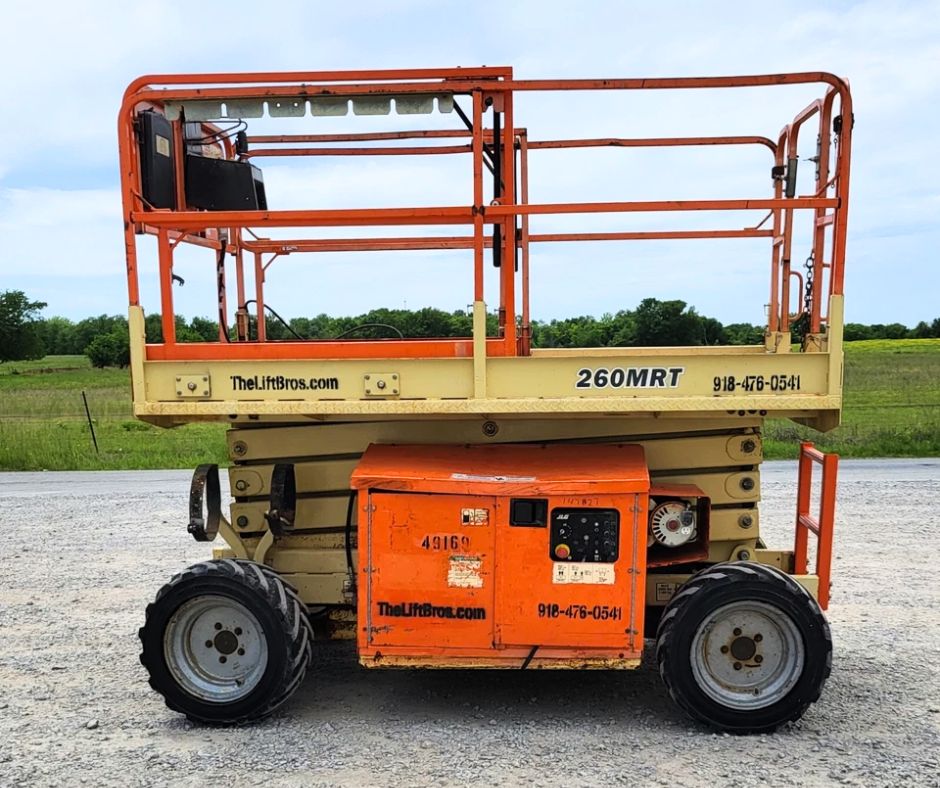 JLG 260MRT rough terrain scissor lift with the deck extension slid out, orange guardrails and operator control box
