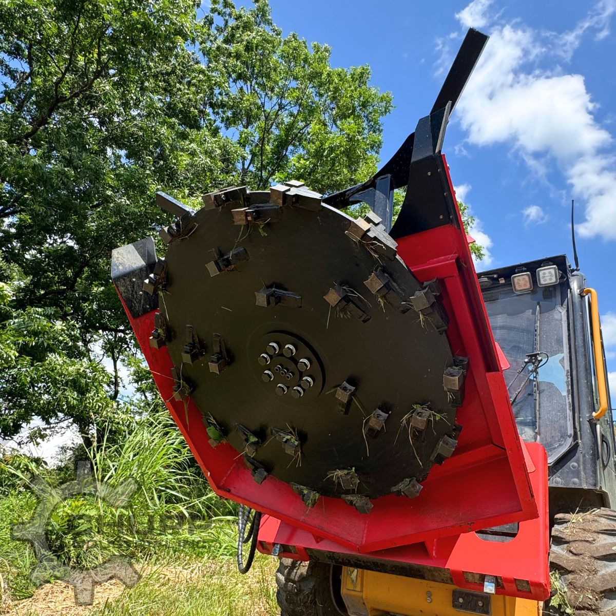 GIYI disc mulcher tilted up on a skid steer, black cutting disc ringed with bolt-on carbide teeth in a red housing