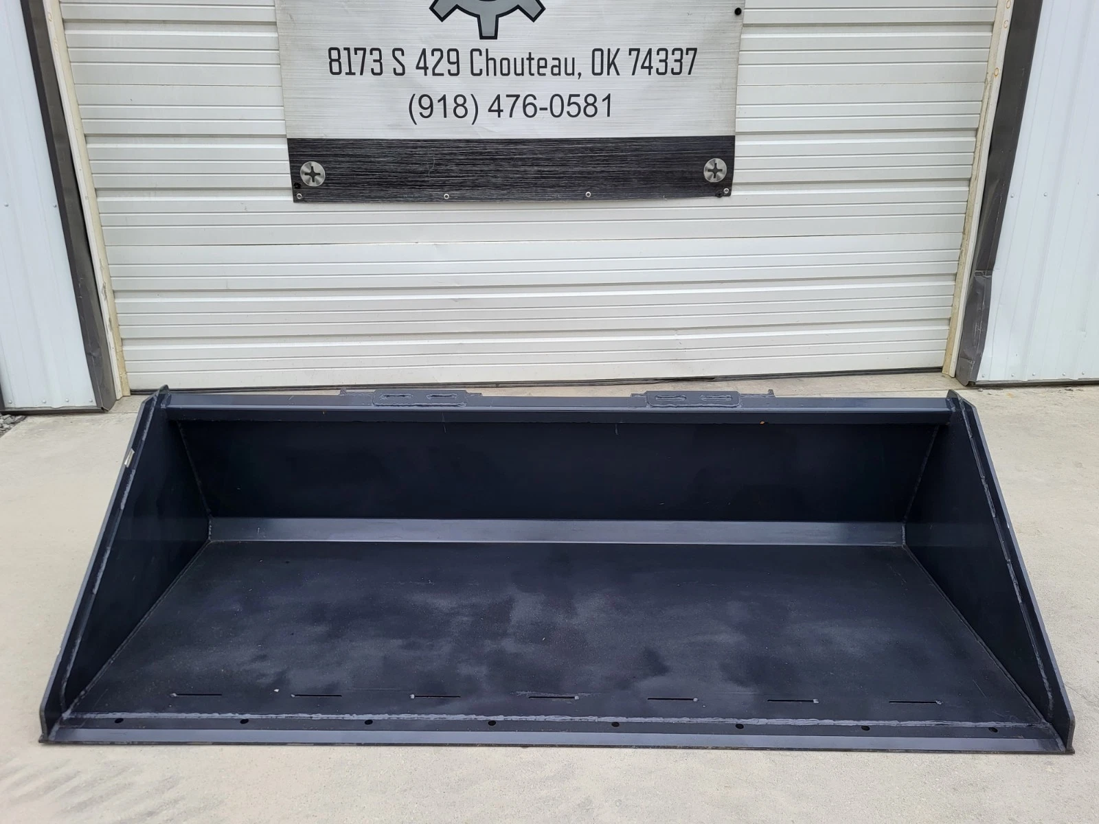 Wolverine 84-inch bucket straight on, open front, sloped side walls and slotted cutting edge