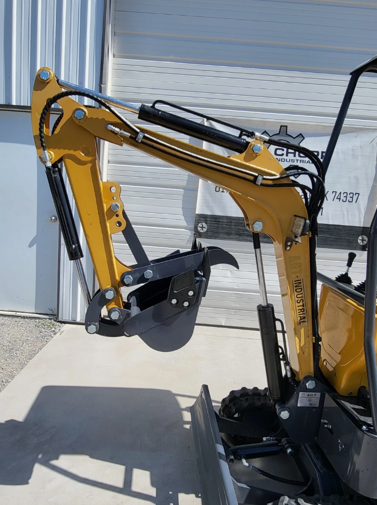 MX12RX mini excavator boom and arm folded in, mechanical thumb closed on the empty quick-attach, LED work light
