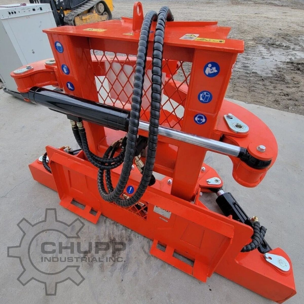 Orange TopCat tree shear from the side: skid steer mount plate, hydraulic cylinder and clamp arm, safety decals