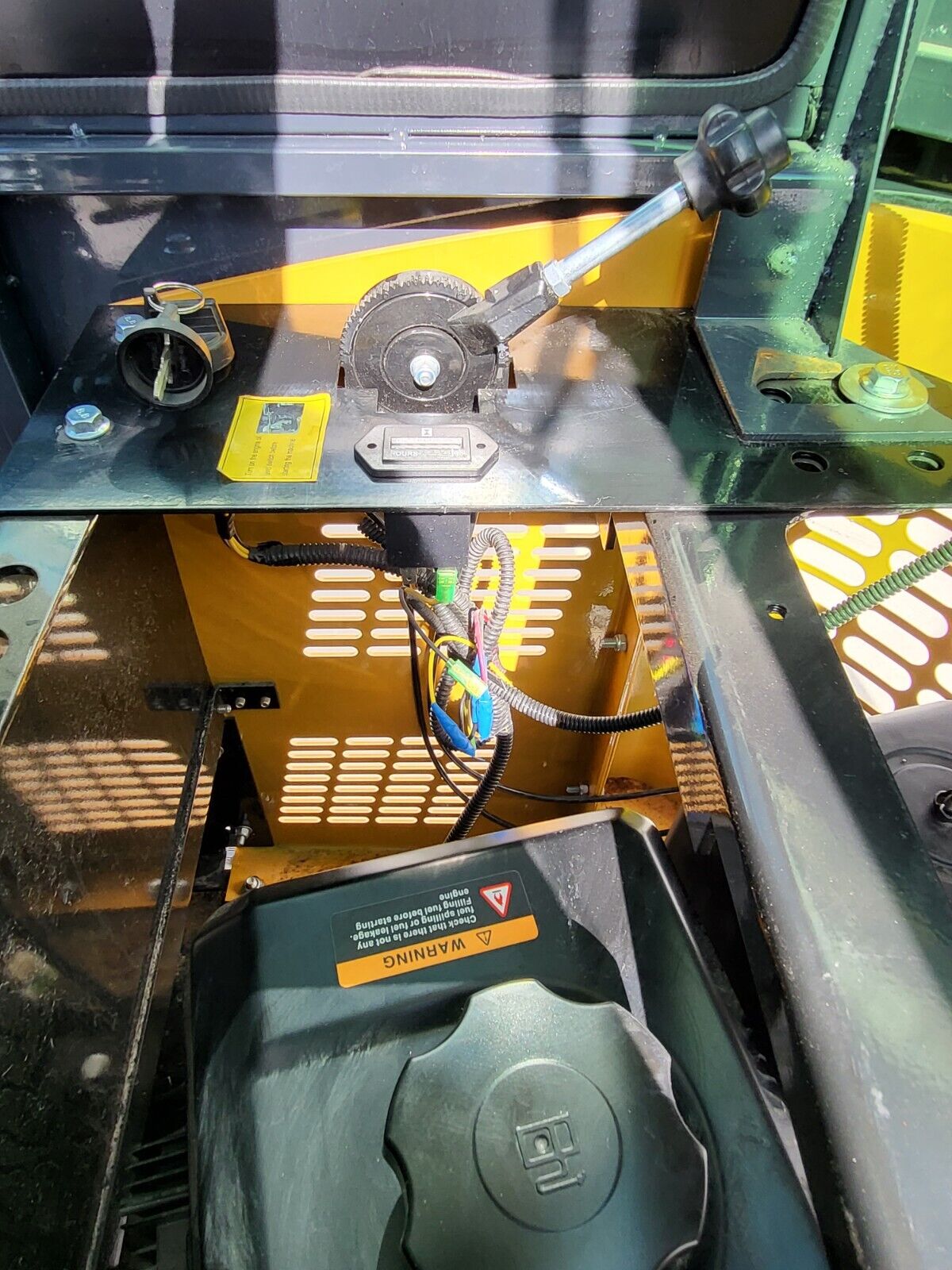 AGT H13R engine bay panel: ignition key switch, hour meter, throttle latch and the capped fuel tank below