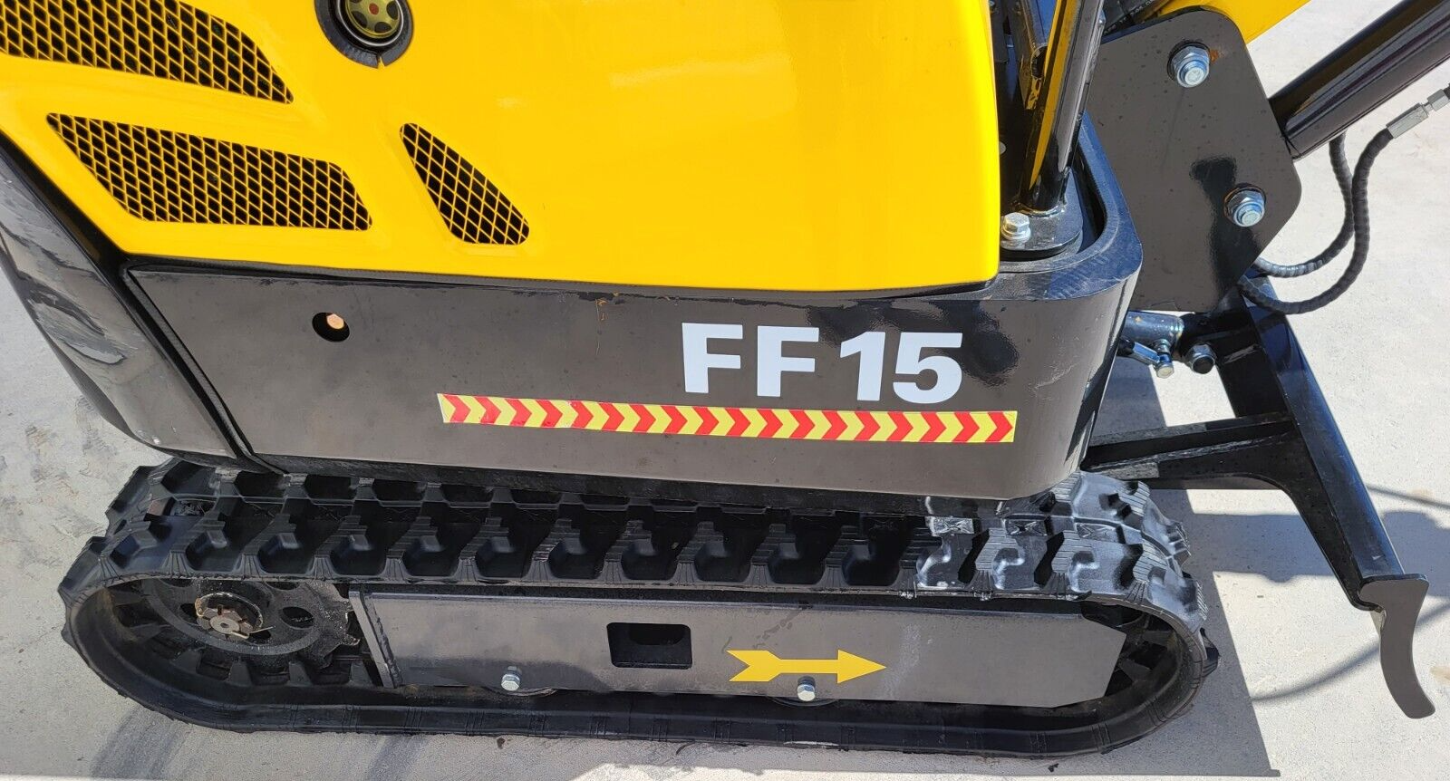 FF15 model decal and chevron reflective stripe on the black side panel, above the rubber track and idler wheel