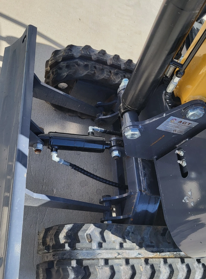 Backfill blade and its hydraulic cylinder on the MX12RX mini excavator, with the boom swing cylinder and tracks