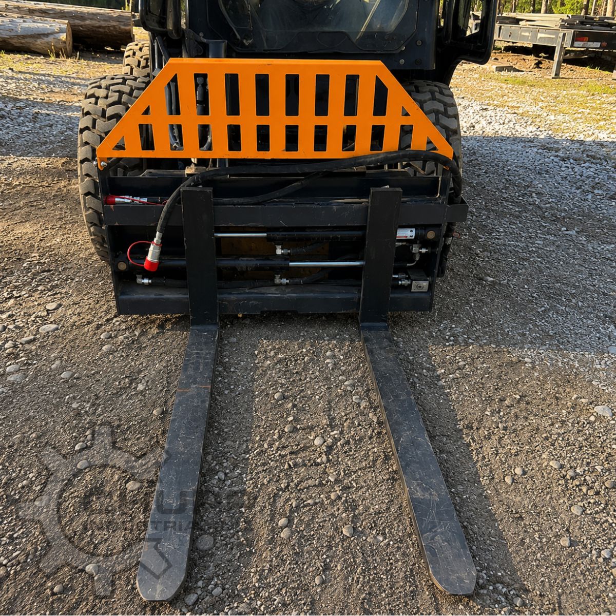 Wolverine 48-inch pallet forks mounted on a skid steer: orange slatted backrest and hydraulic fork-positioning cylinder