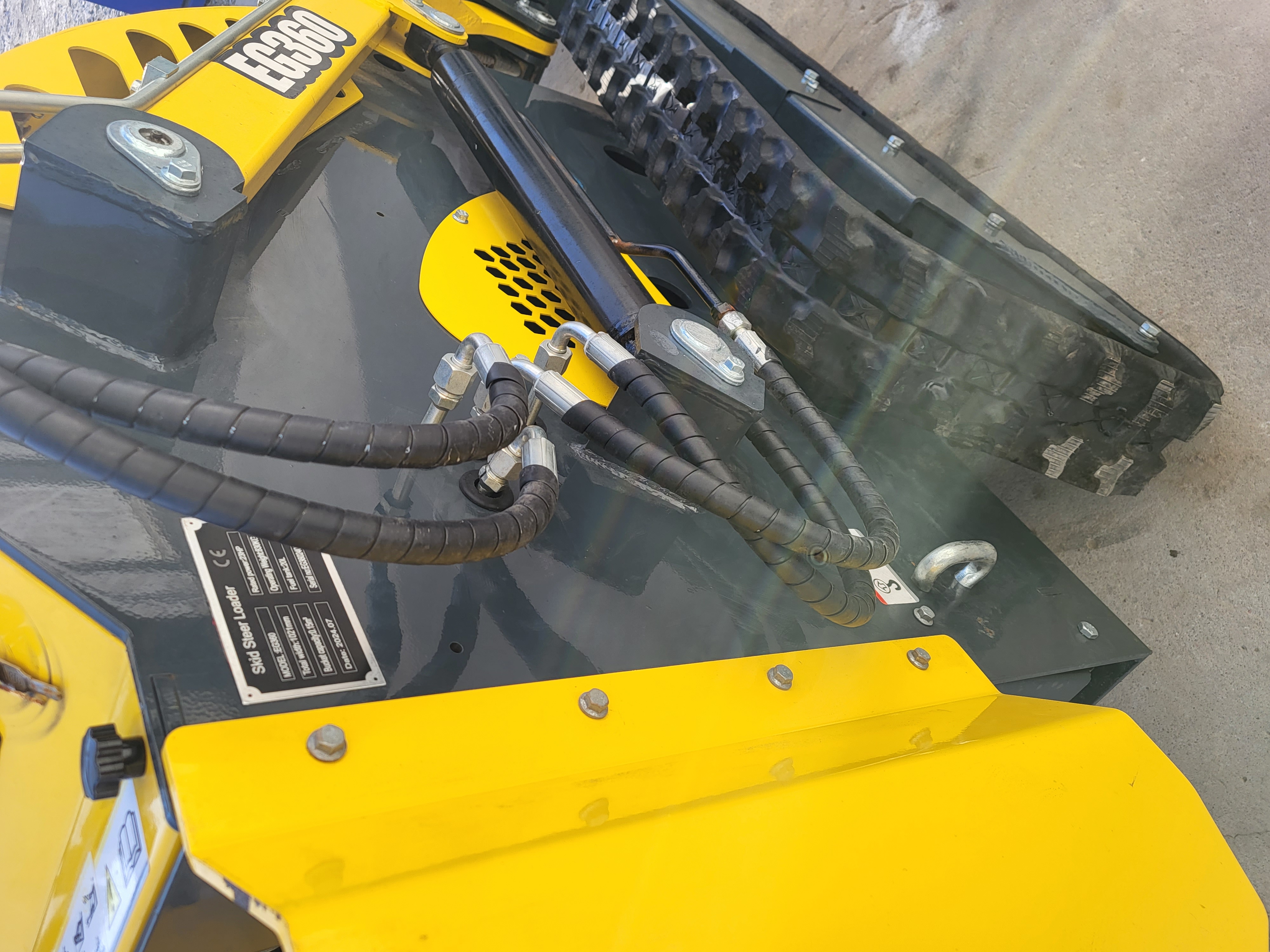 EGN EG360 rear deck: lift cylinder and hydraulic hoses beside the data plate - 1021 mm width, 0.15 cubic metre bucket