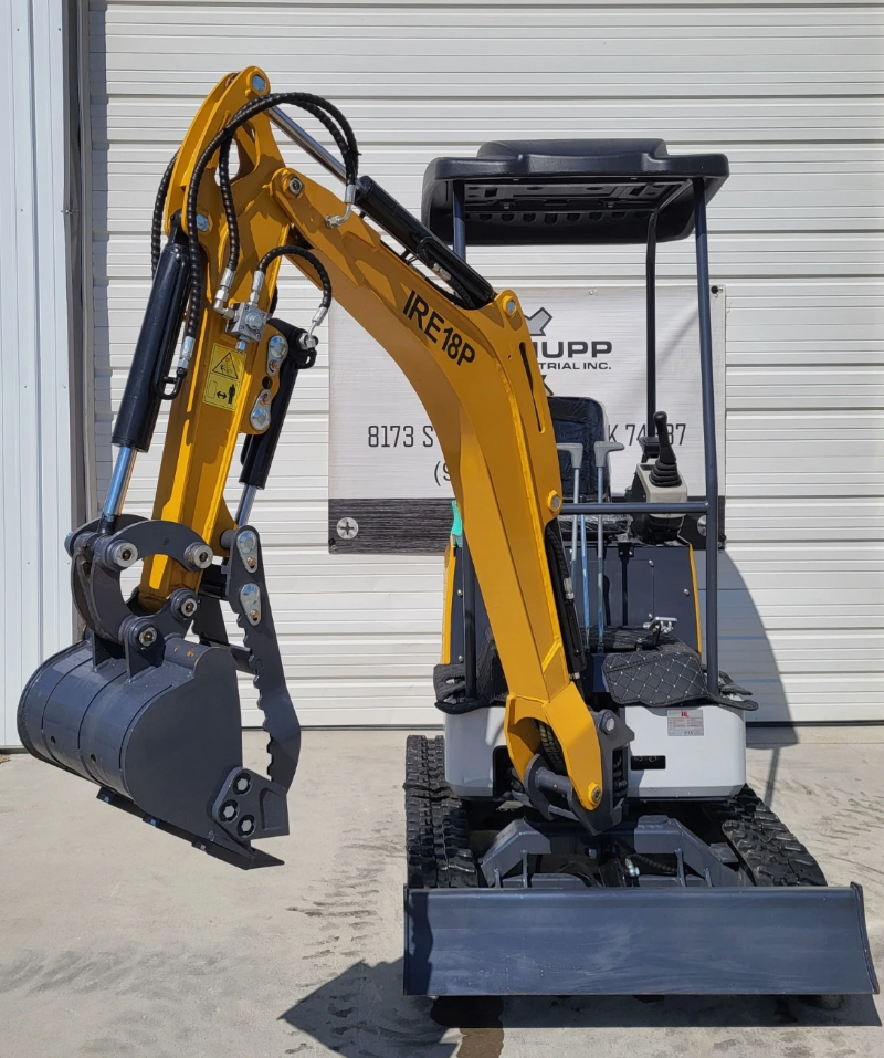 IRE18P mini excavator with raised boom, toothed bucket, hydraulic thumb and gray dozer blade