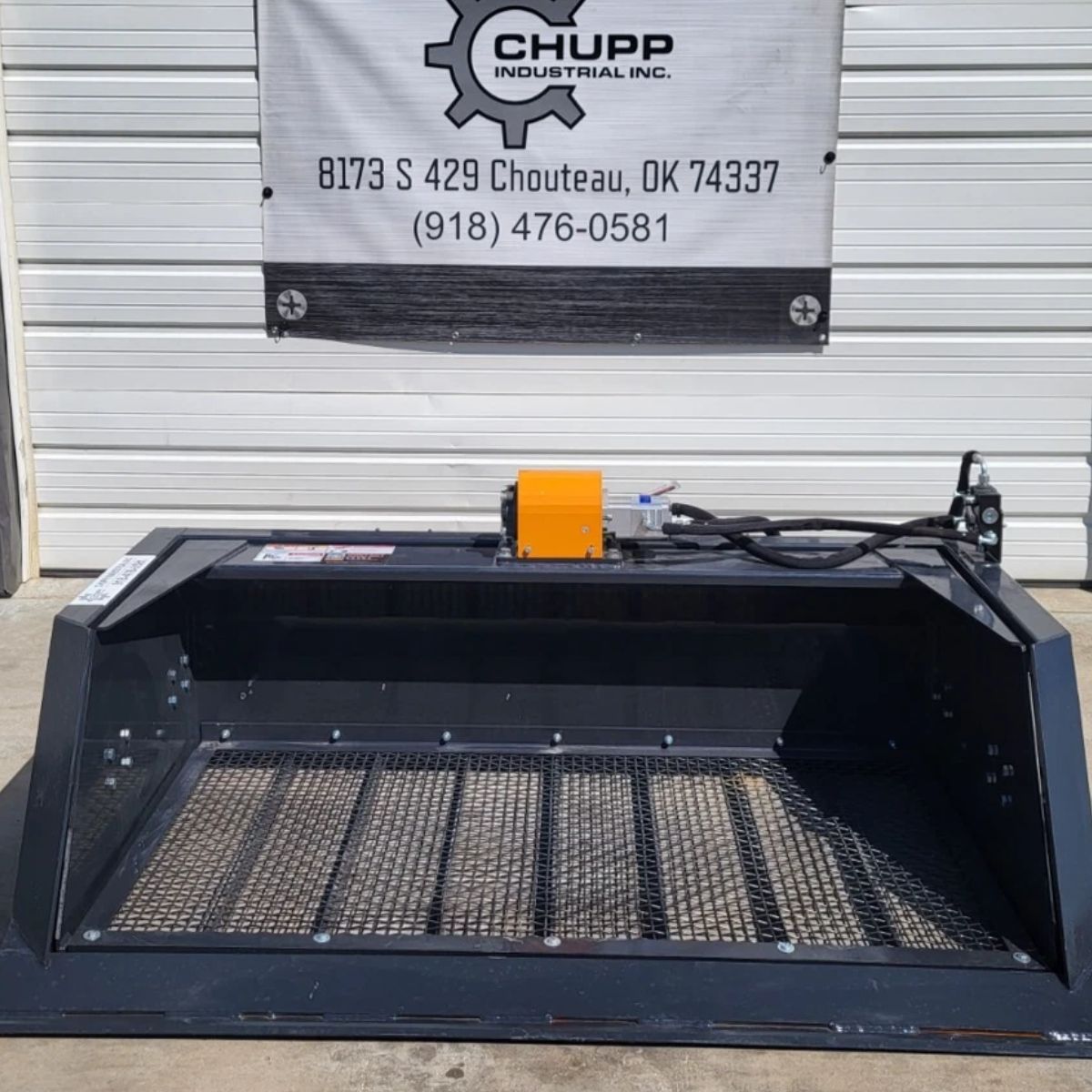Wolverine screening bucket: steel mesh screen floor with an orange hydraulic drive motor and hoses on top