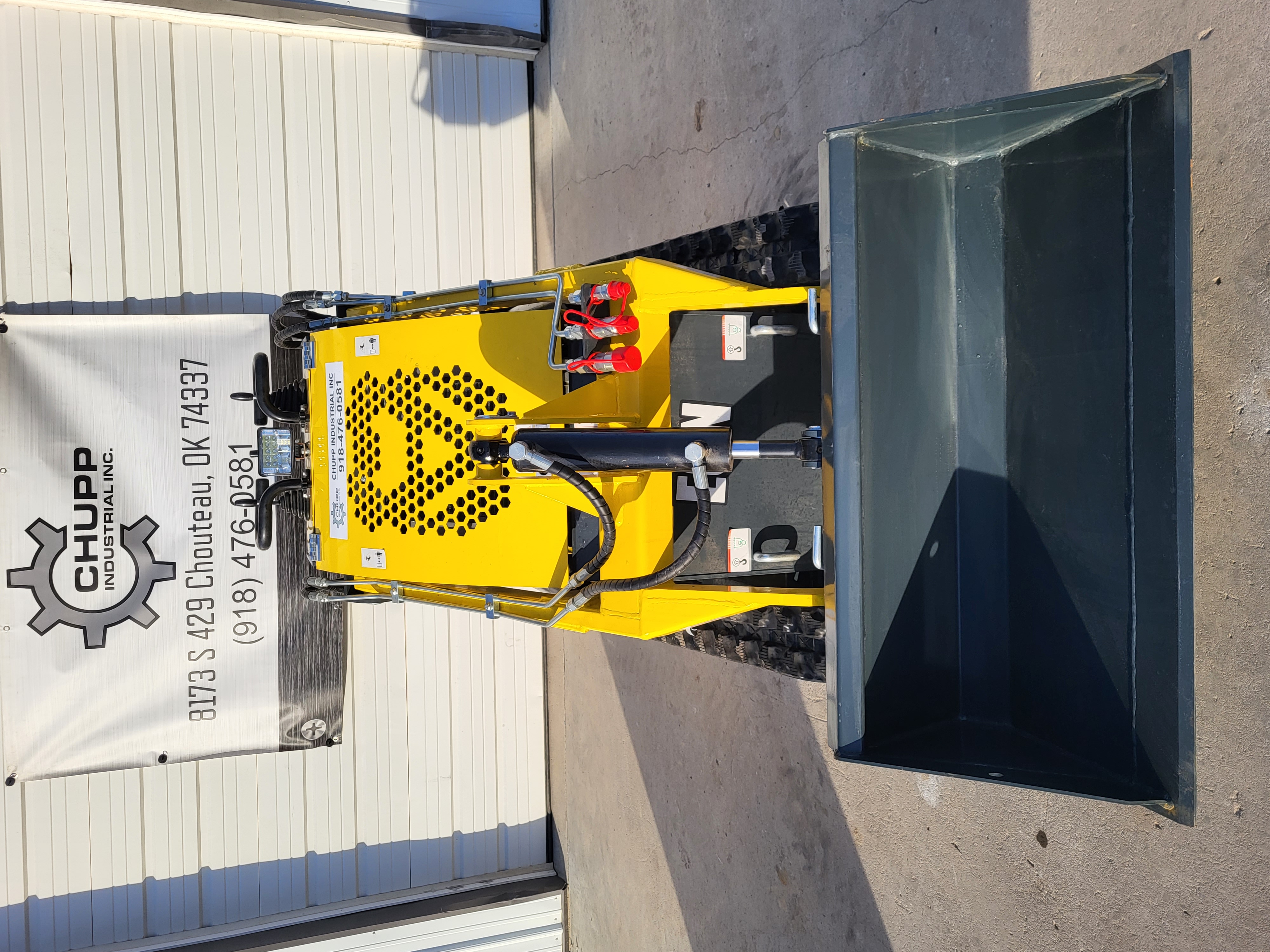 EG360 head-on: wide dirt bucket lowered flat, tilt cylinder, red-capped hydraulic couplers and vented engine hood