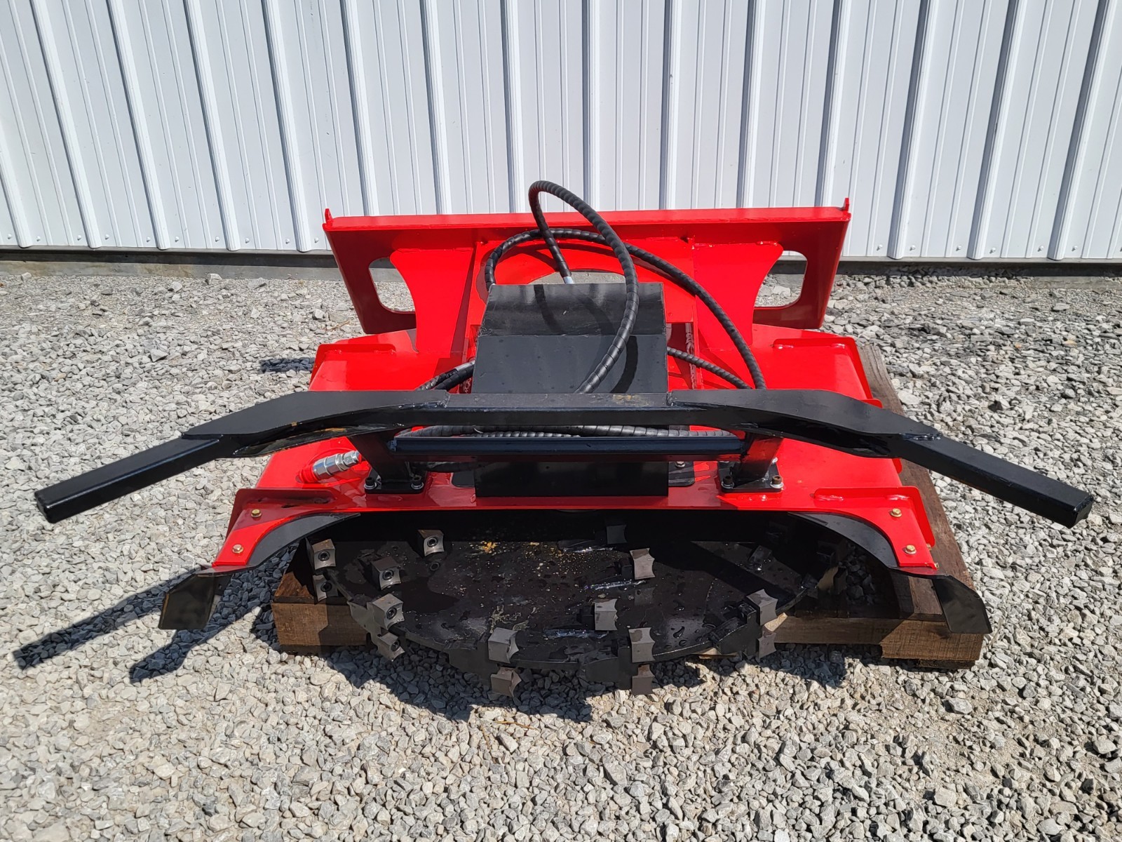 Red disc mulcher on a pallet, cutting disc with replaceable carbide teeth and hydraulic drive motor