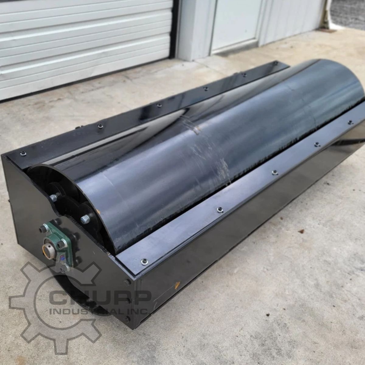 GIYI vibratory roller attachment: wide steel drum in a black frame with a pillow block bearing at the drum end