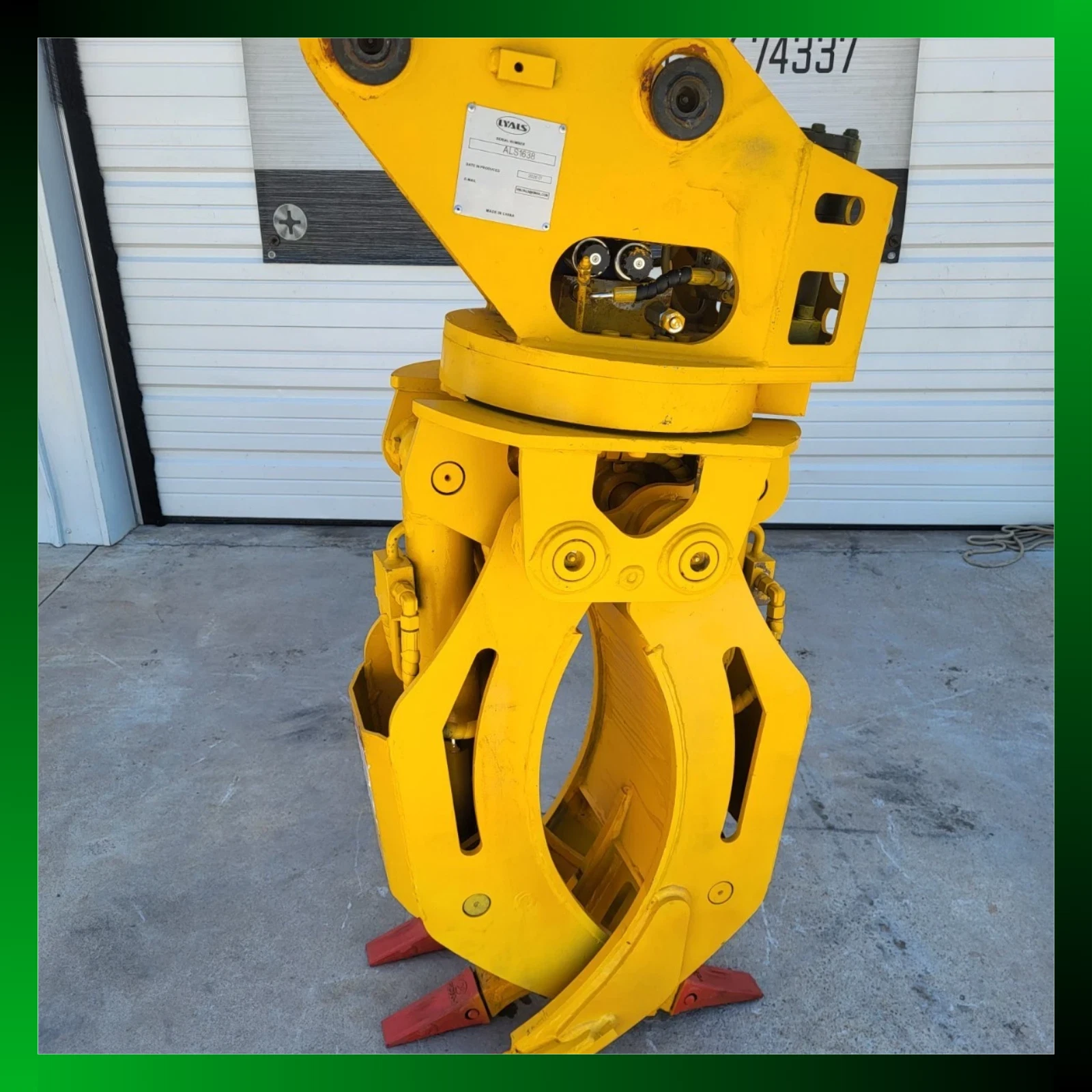Yellow ALS1638 rotating grapple, jaws open, LYALS serial plate and rotator bearing, framed by a green border