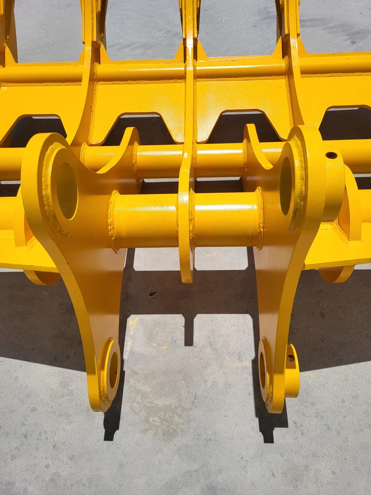 Twin mounting arms and pin bores on the yellow rake, cross tubes and cut-out back plate behind
