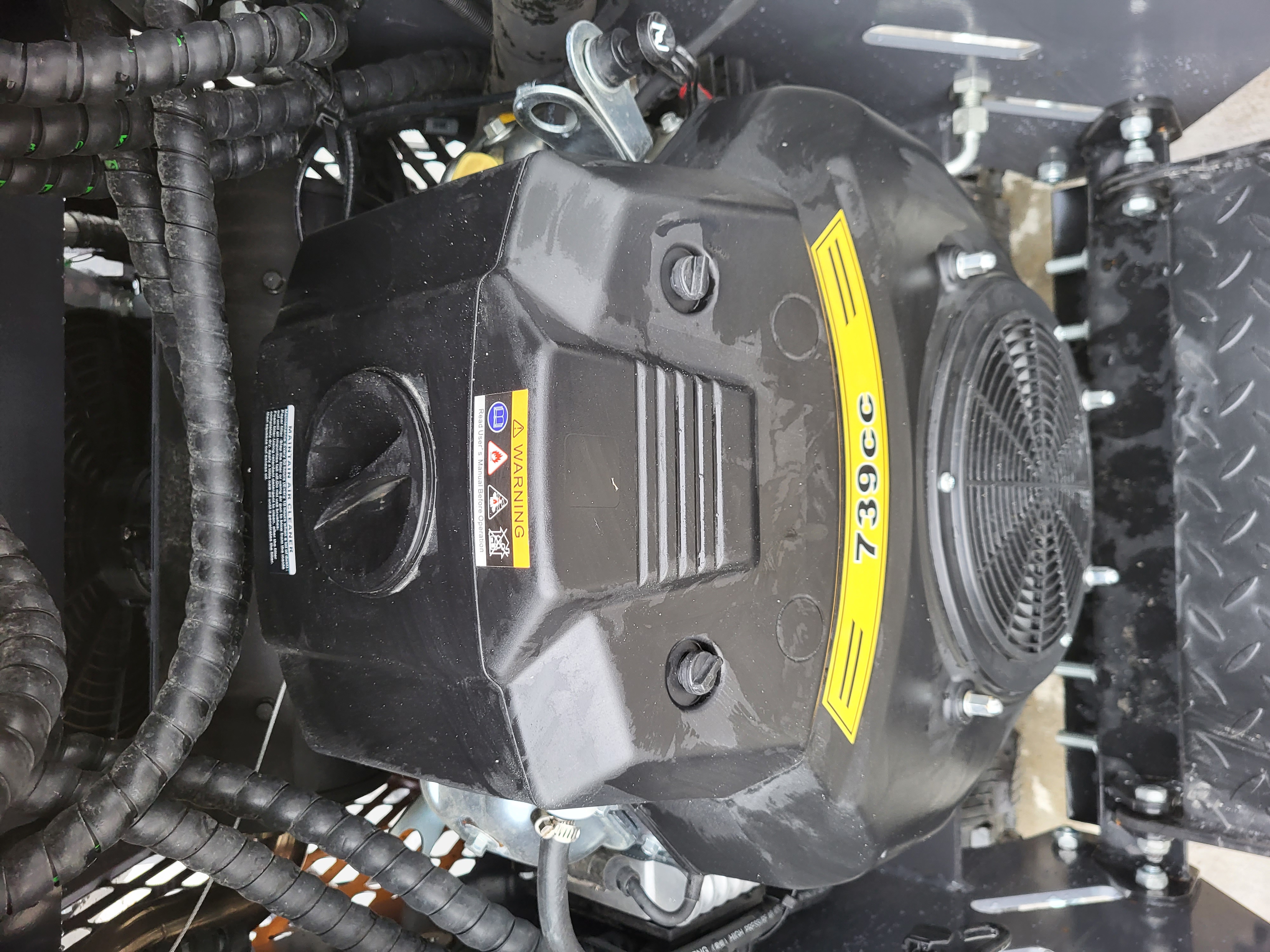 KRT23 739cc gasoline engine under the open cover: molded shroud, air cleaner and flywheel fan screen