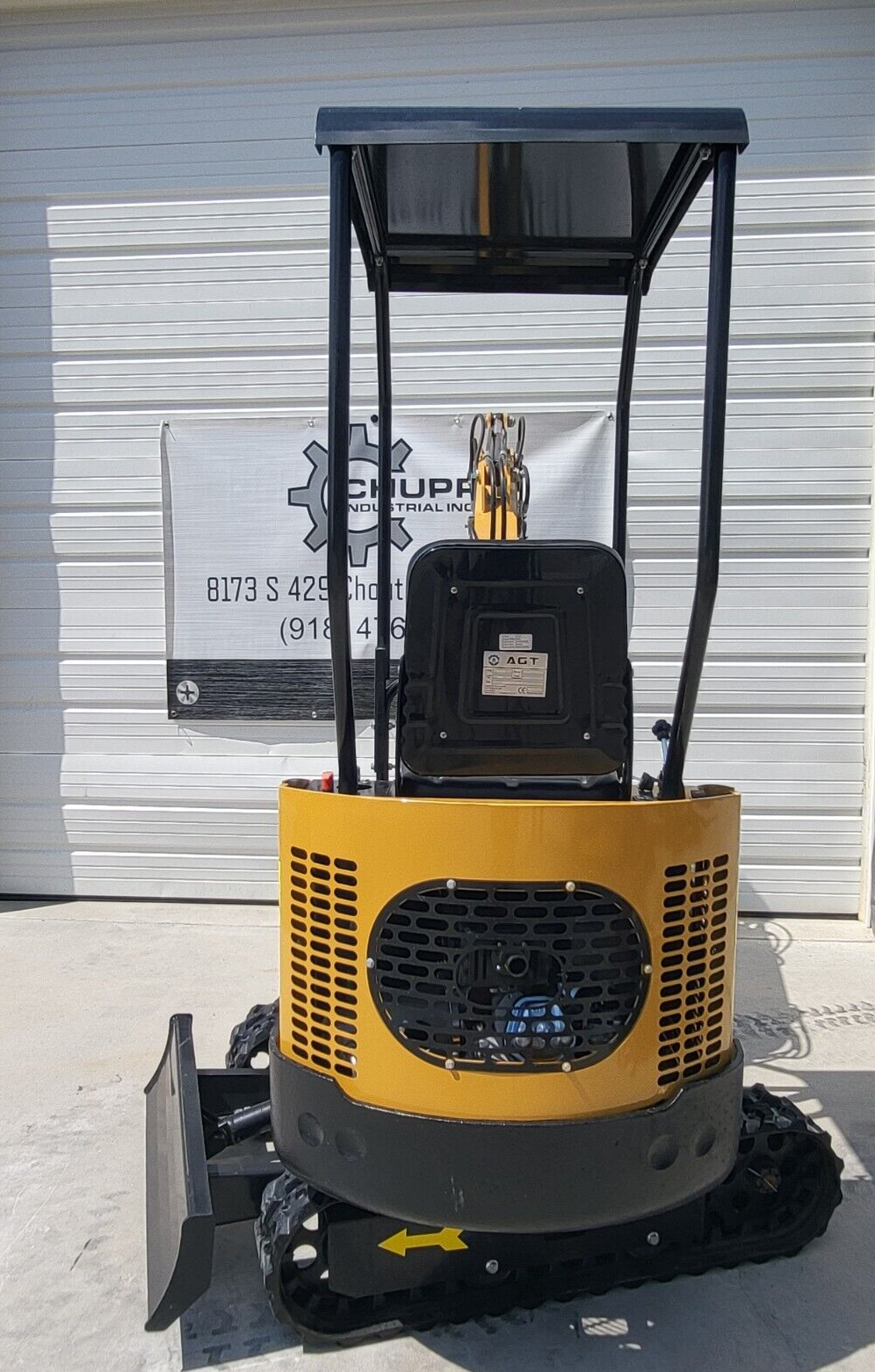 AGT H12R mini excavator from behind: vented yellow engine cowl and counterweight, seat back with AGT plate, canopy