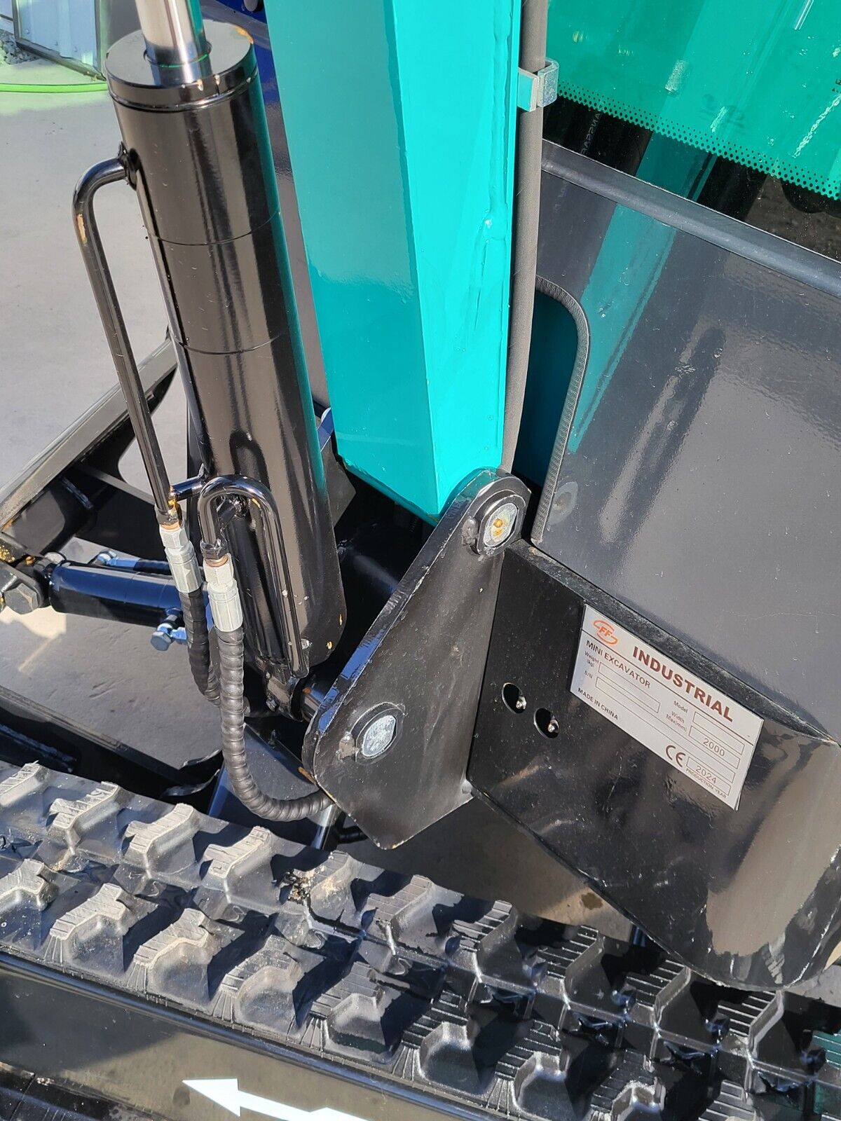 FF13 boom swing bracket with the FF Industrial mini excavator data plate, swing cylinder and hoses above the track