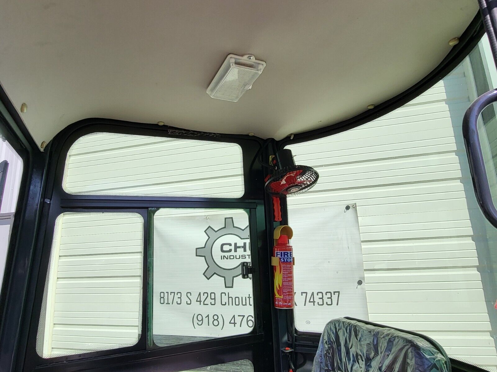 AGT H13R cab interior: dome light, mounted fan, fire extinguisher and wrap-around glass above the seat