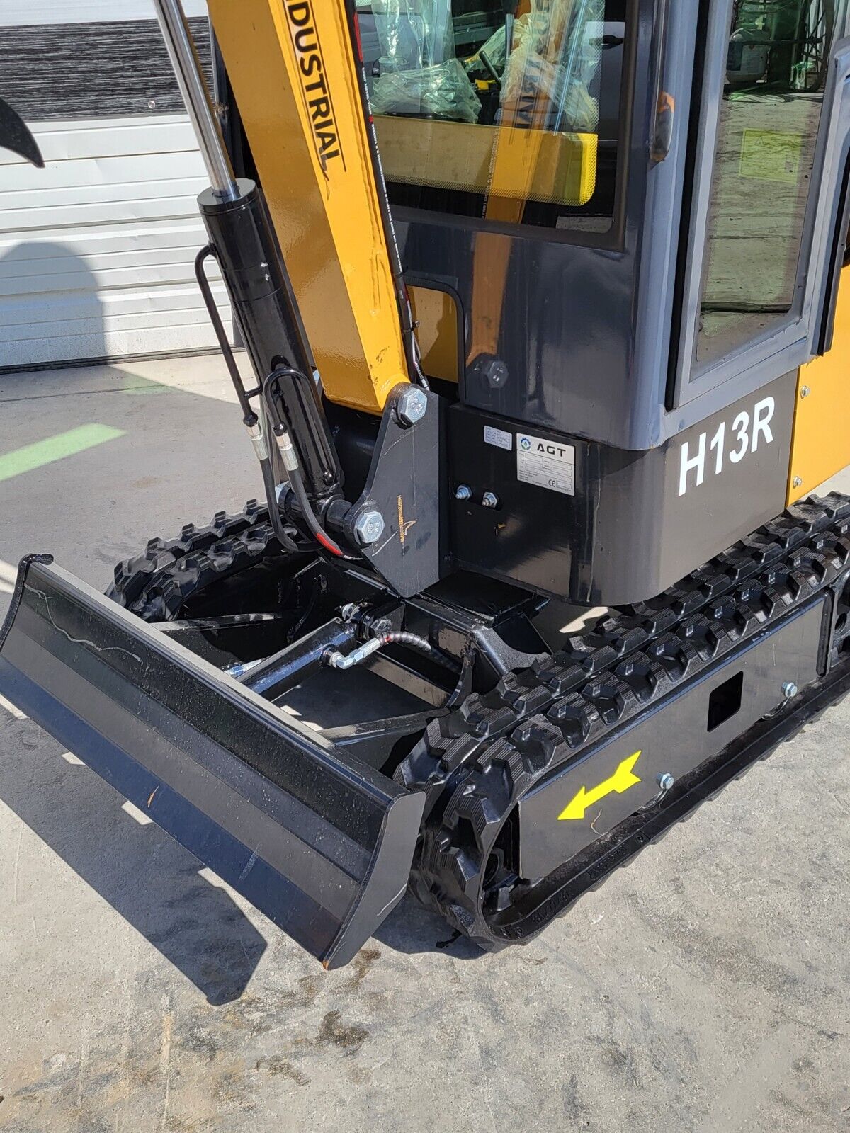 AGT H13R dozer blade and boom pivot cylinder between the rubber tracks, H13R decal on the cab side