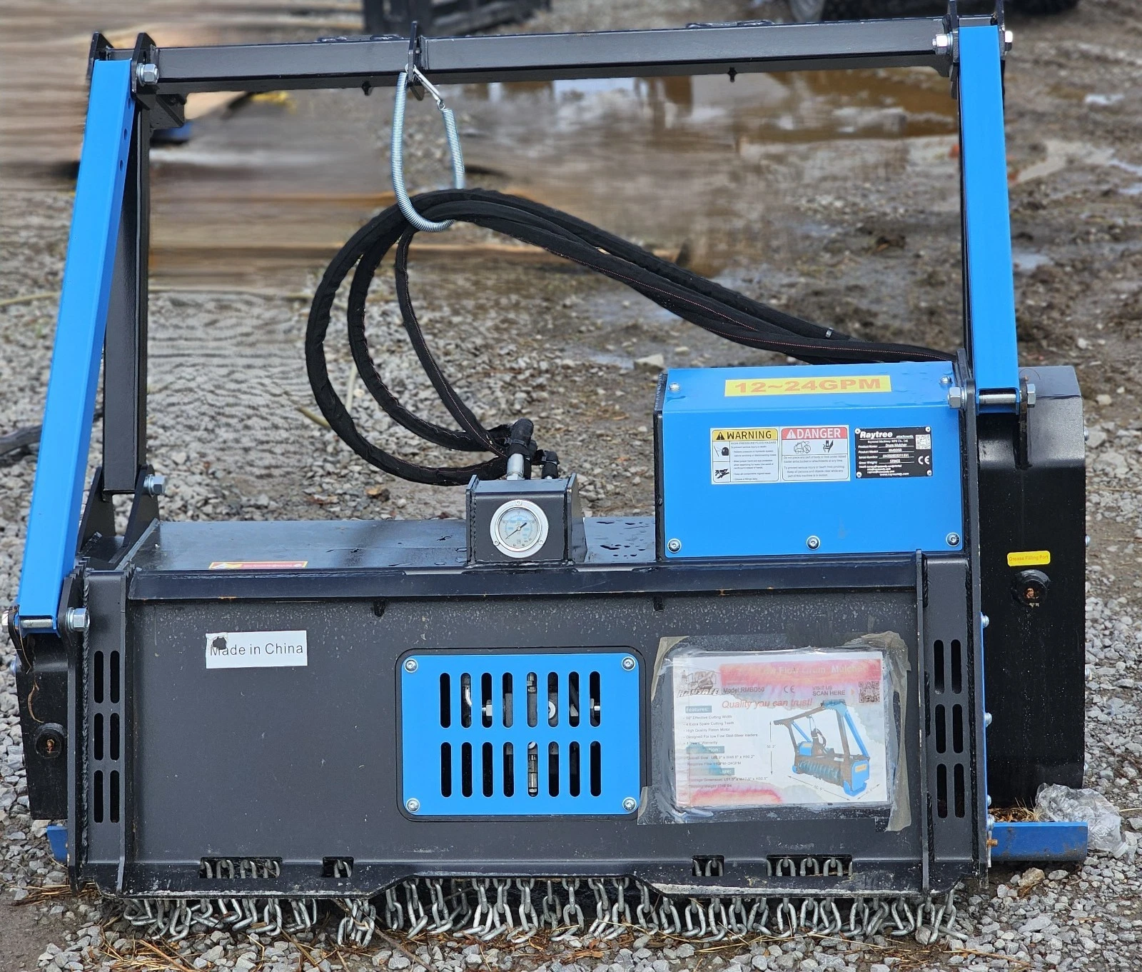 Raytree drum mulcher, 12-24 GPM decal on the blue motor housing beside the pressure gauge