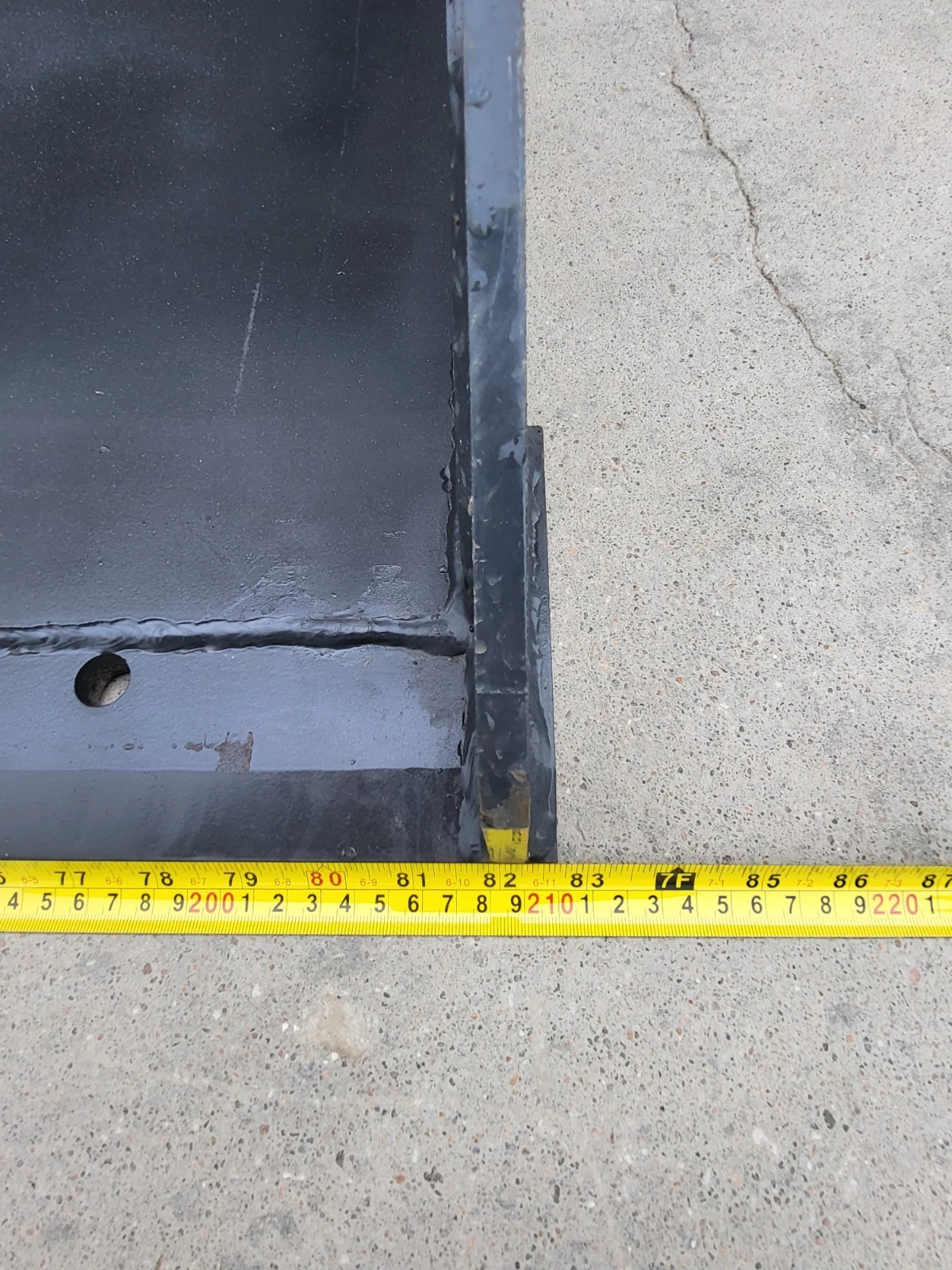Tape measure along the front of the bucket, its corner falling at about 84 inches