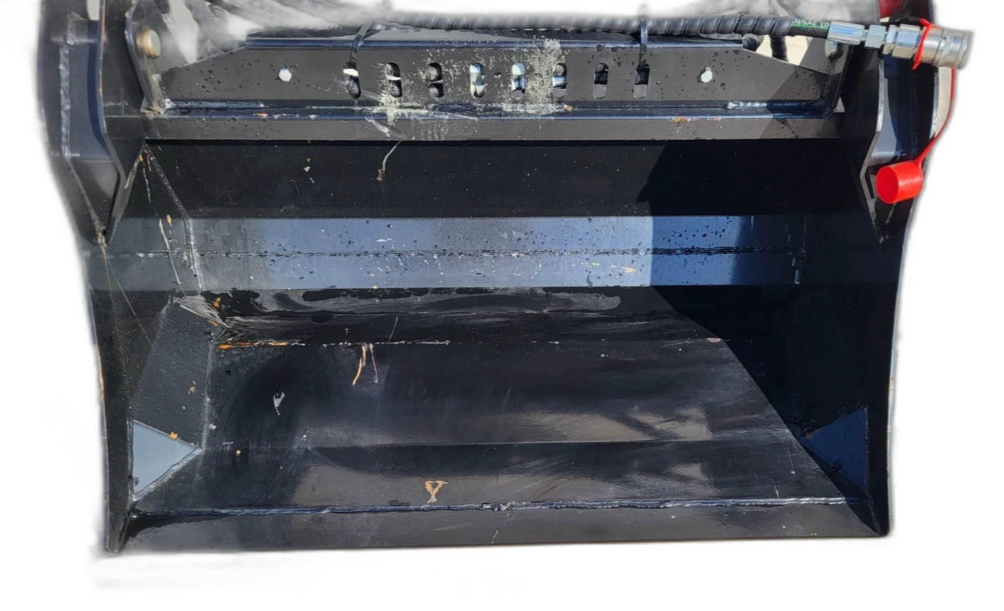 Black 4-in-1 bucket, clam jaw open above the slotted top rail, hose and red-capped coupler at the side